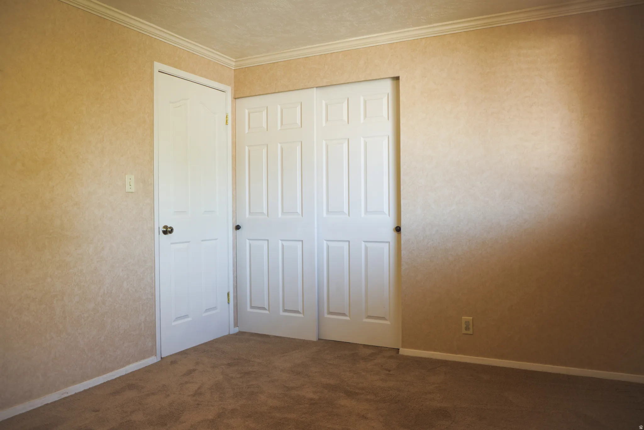 Bedroom two featuring dark colored carpet, crown molding, and a closet