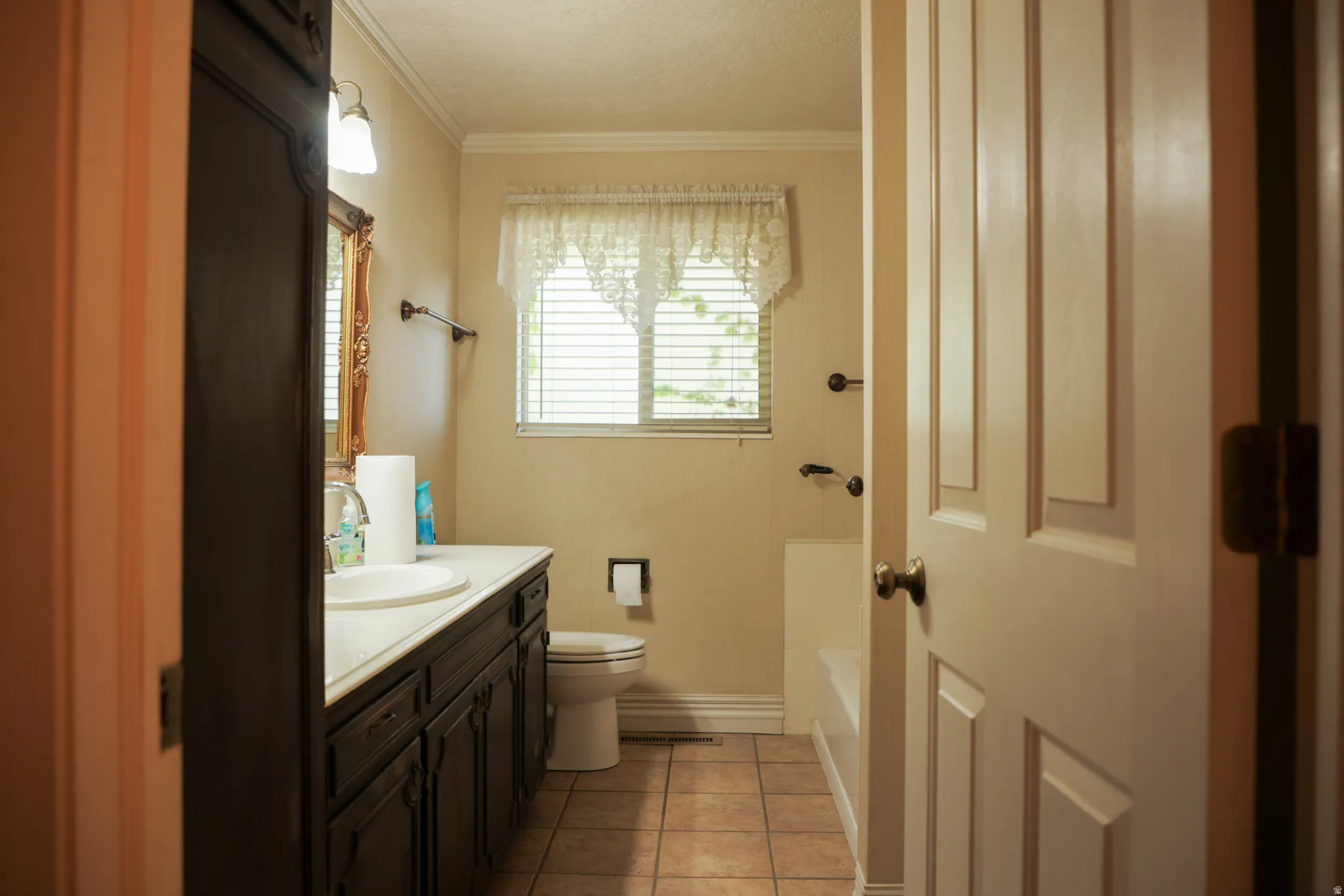 Full bathroom featuring vanity, crown molding, light tile patterned floors, a bath, and a shower