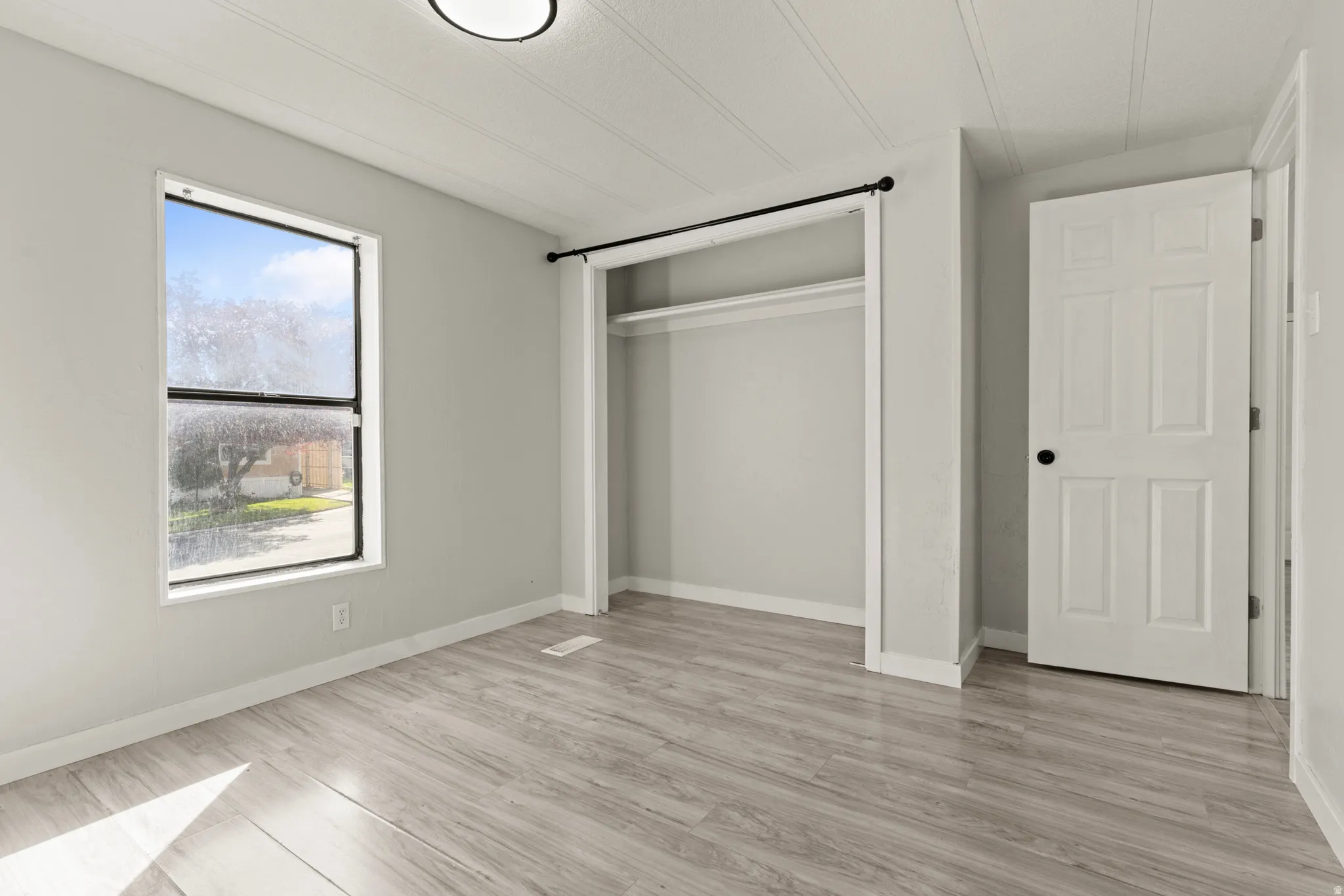 Unfurnished bedroom featuring a closet and light wood-style flooring