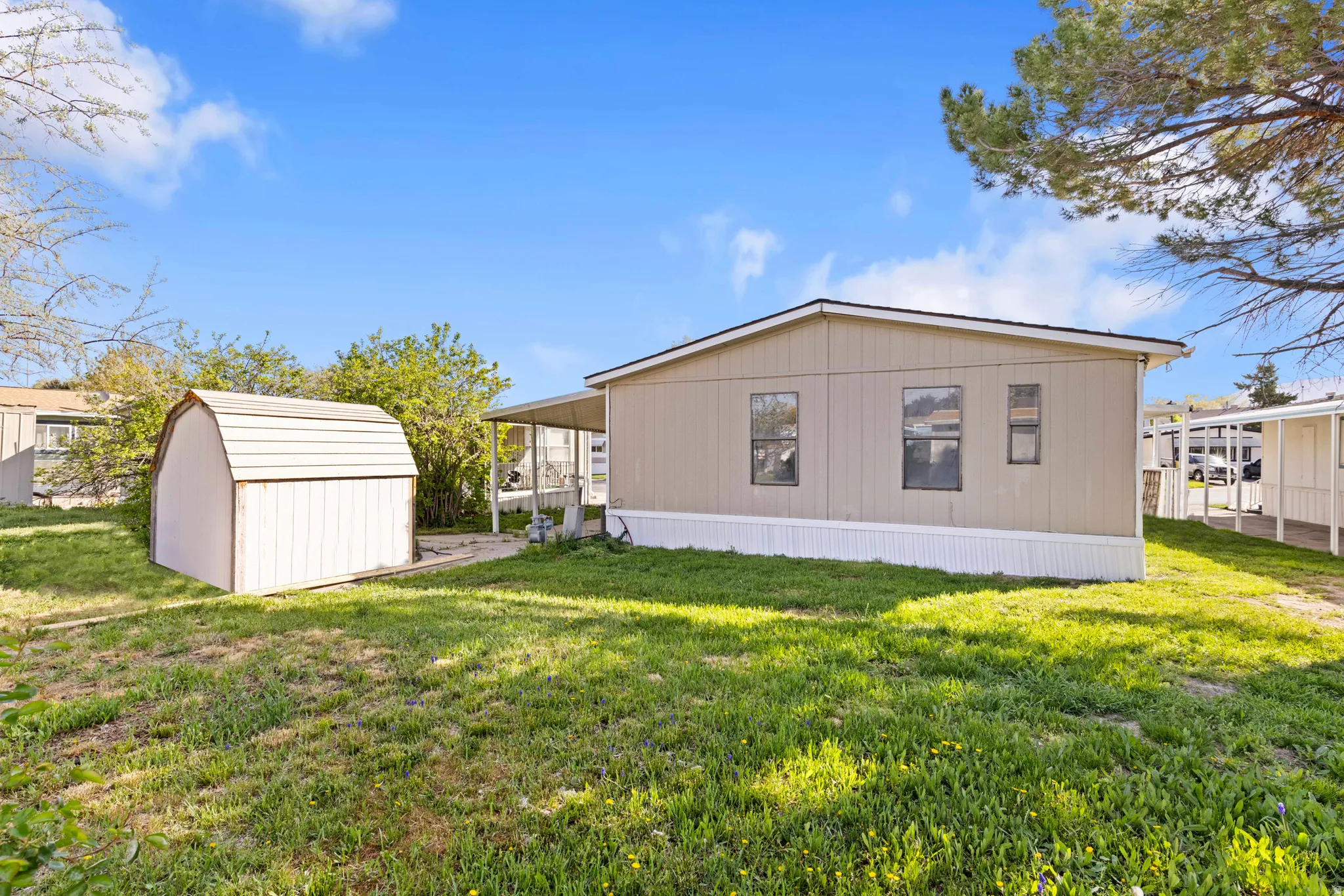 Back of property featuring a lawn and a storage shed