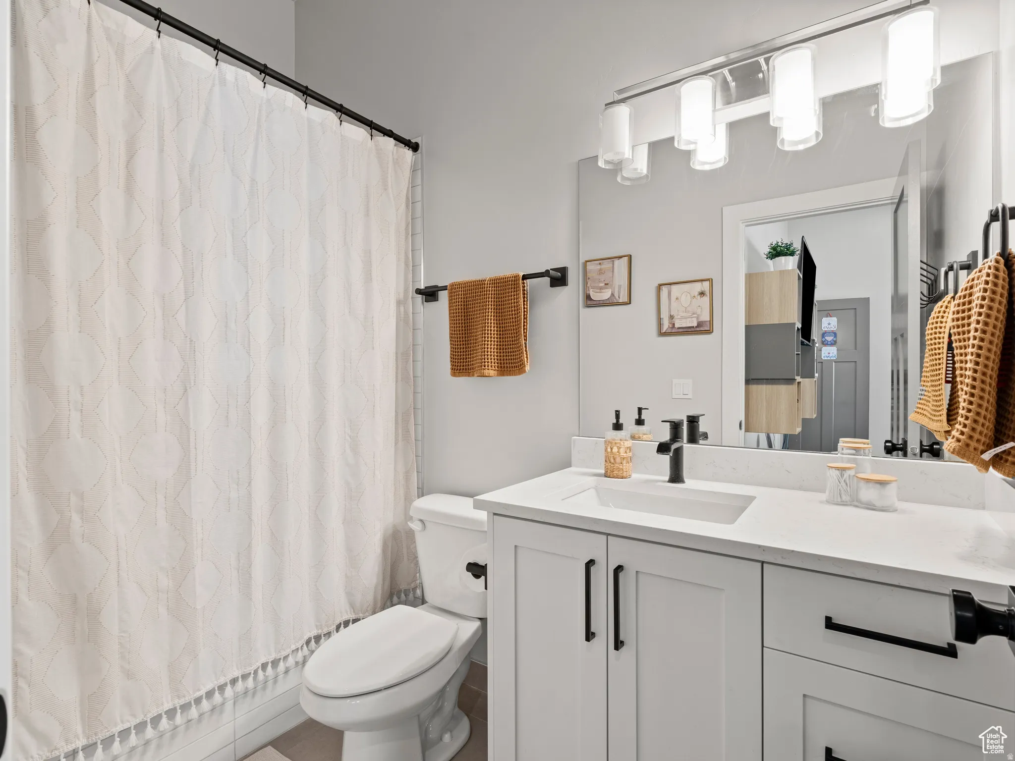 Full his & her bathroom suite featuring a shower with curtain and quartz vanity