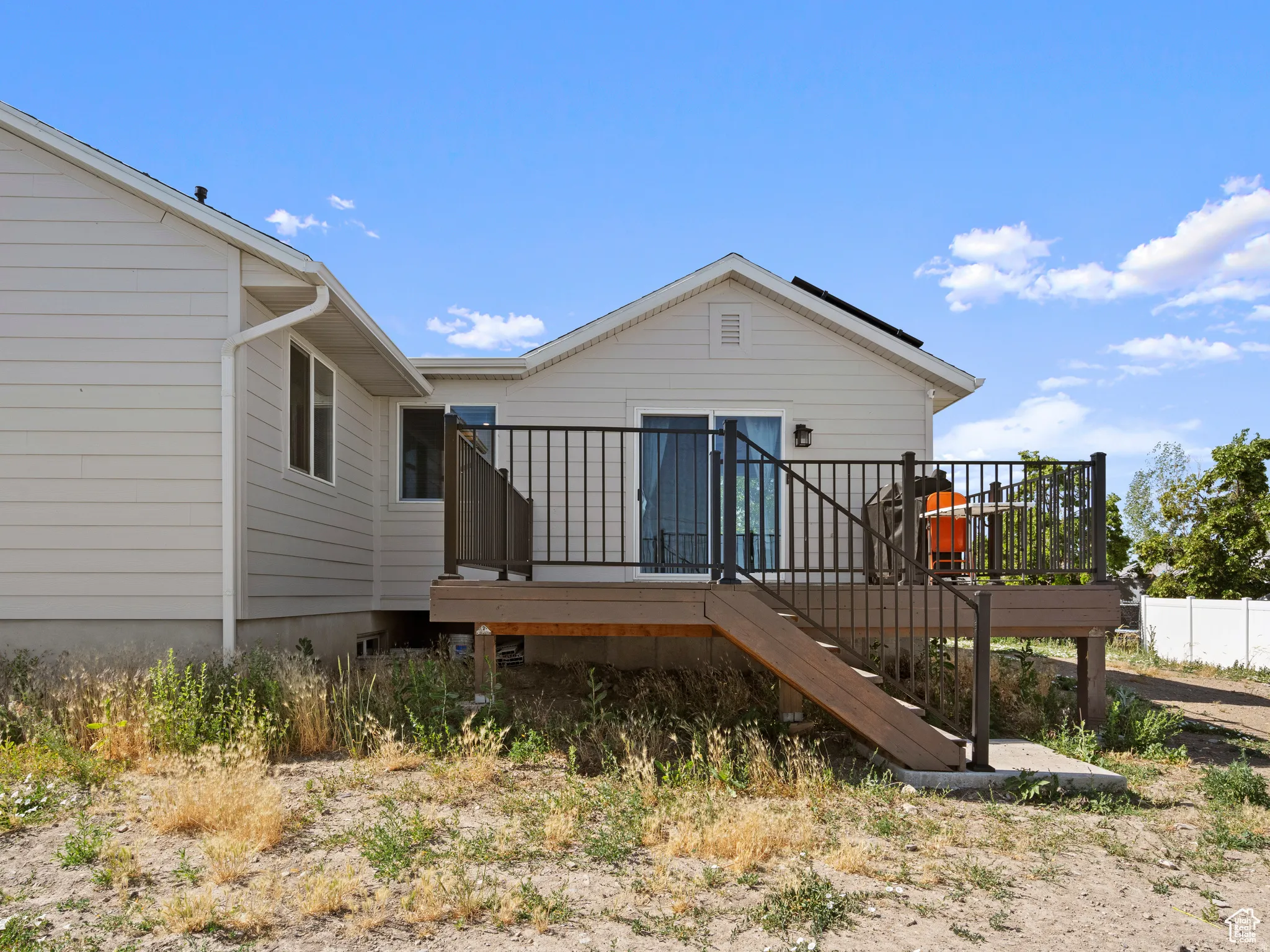 Rear view of property featuring a wooden deck.