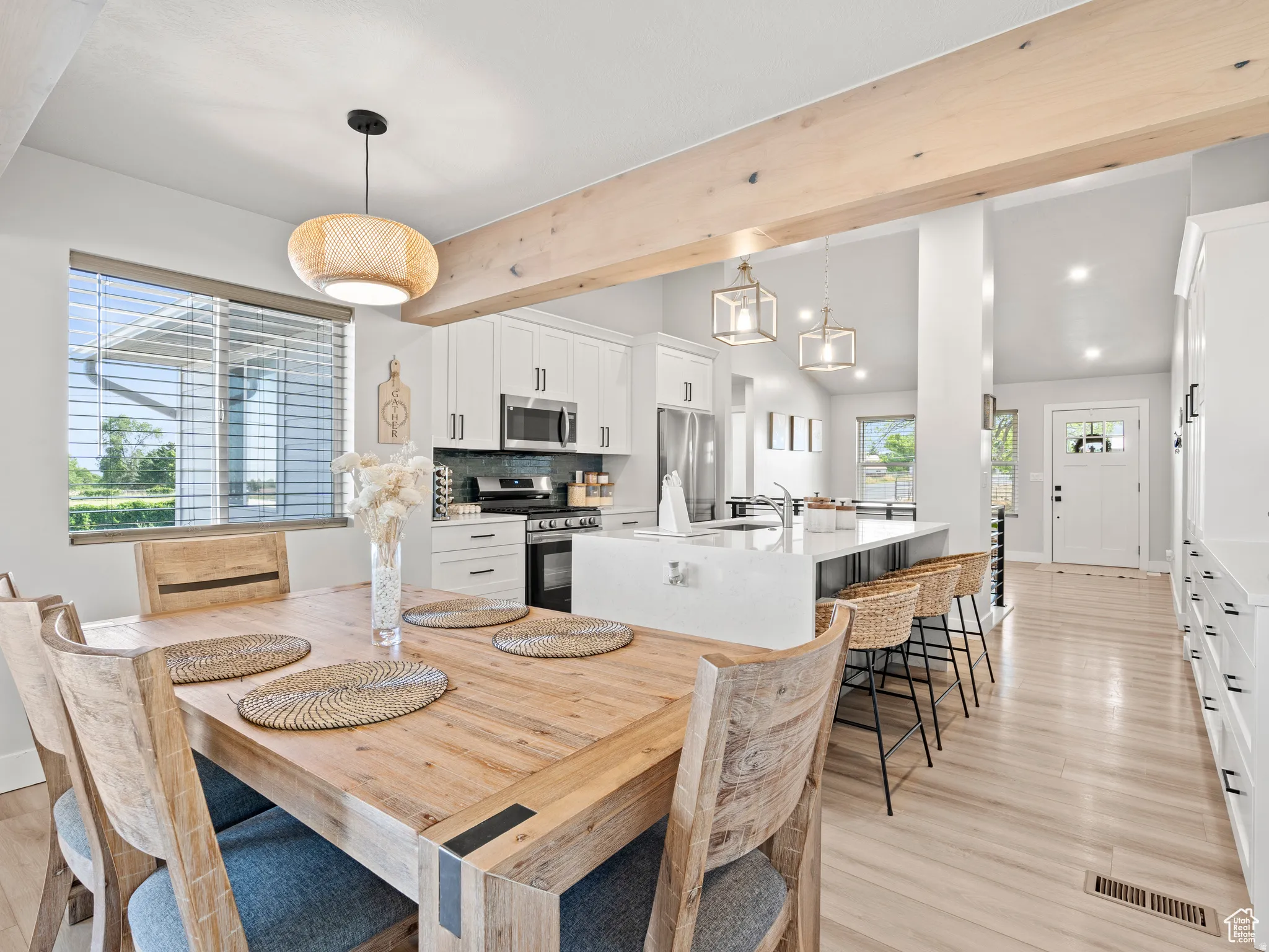 Open Dining area featuring lofted ceiling with beams and light wood finished floors. Open concepts