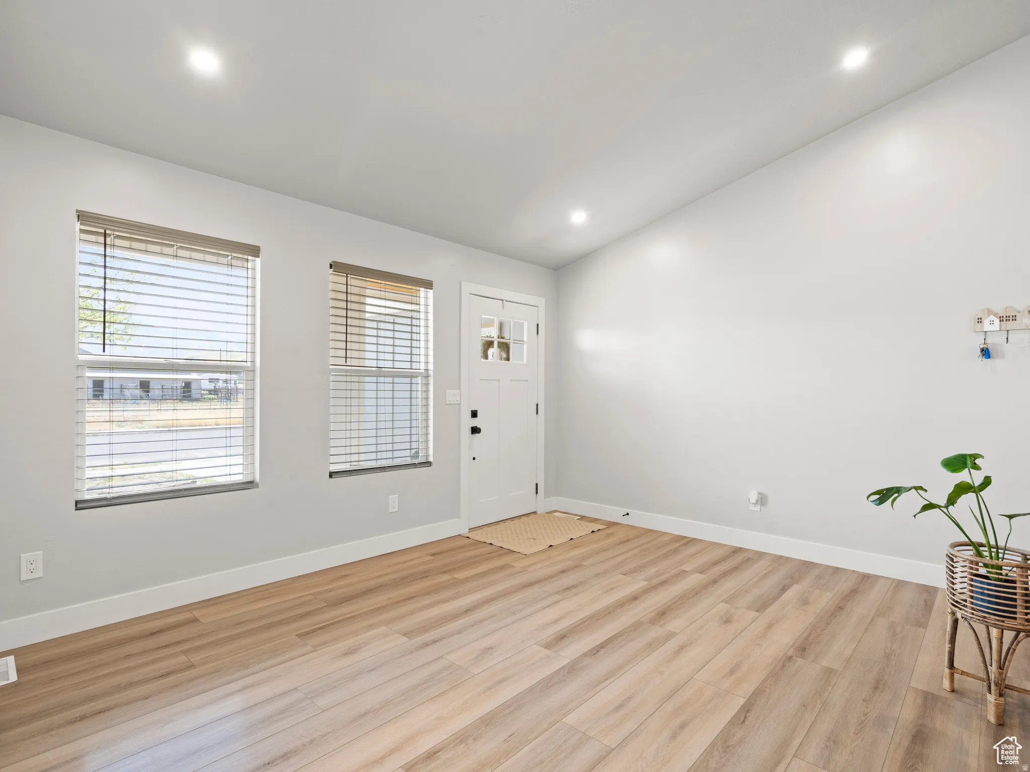 Entrance foyer featuring light wood finished floors, vaulted ceiling, and recessed lighting