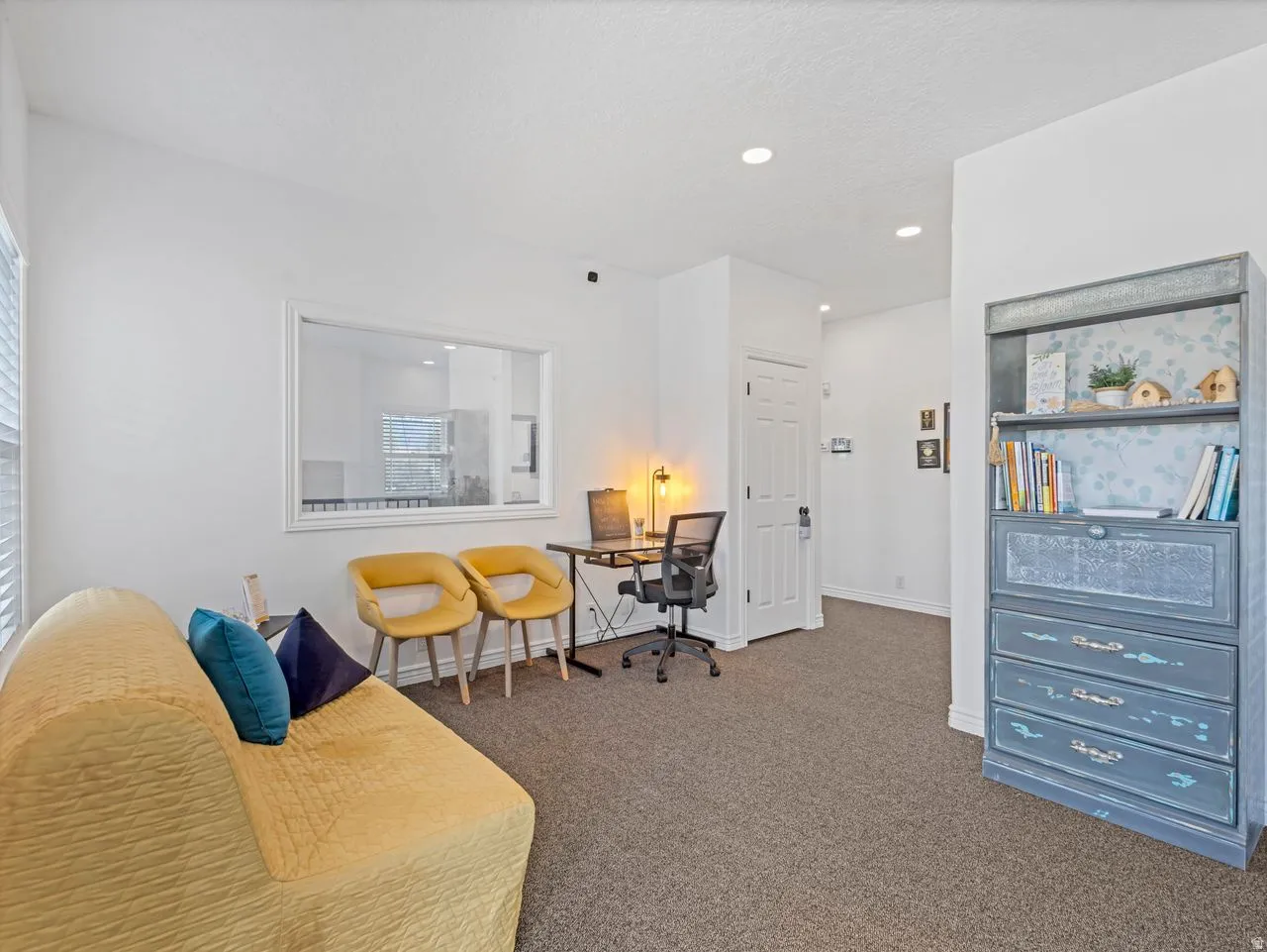 Waiting room area with colored carpet, recessed lighting all in a office area