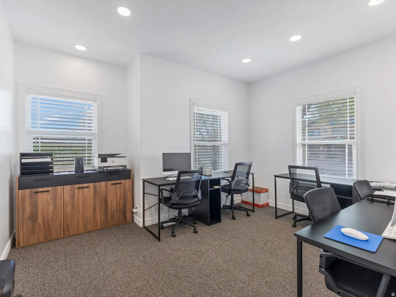 Office with colored carpet and recessed lighting
