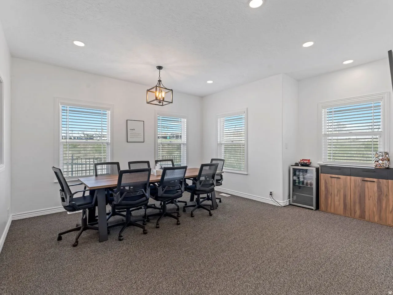 Office with beverage cooler, dark carpet, plenty of natural light, recessed lighting, and a textured ceiling