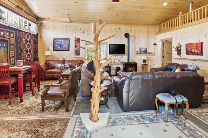 Living area with healthy amount of natural light, wood ceiling, and concrete floors