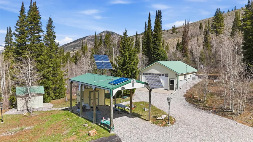 View of front of property featuring ground mounted solar panels, an outbuilding, and a mountain view
