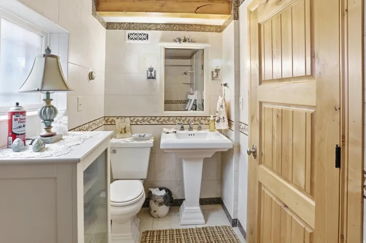 Bathroom featuring tile walls, light tile patterned floors, and a shower