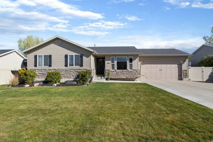 Single story home with stone siding, driveway, a garage, and a gate