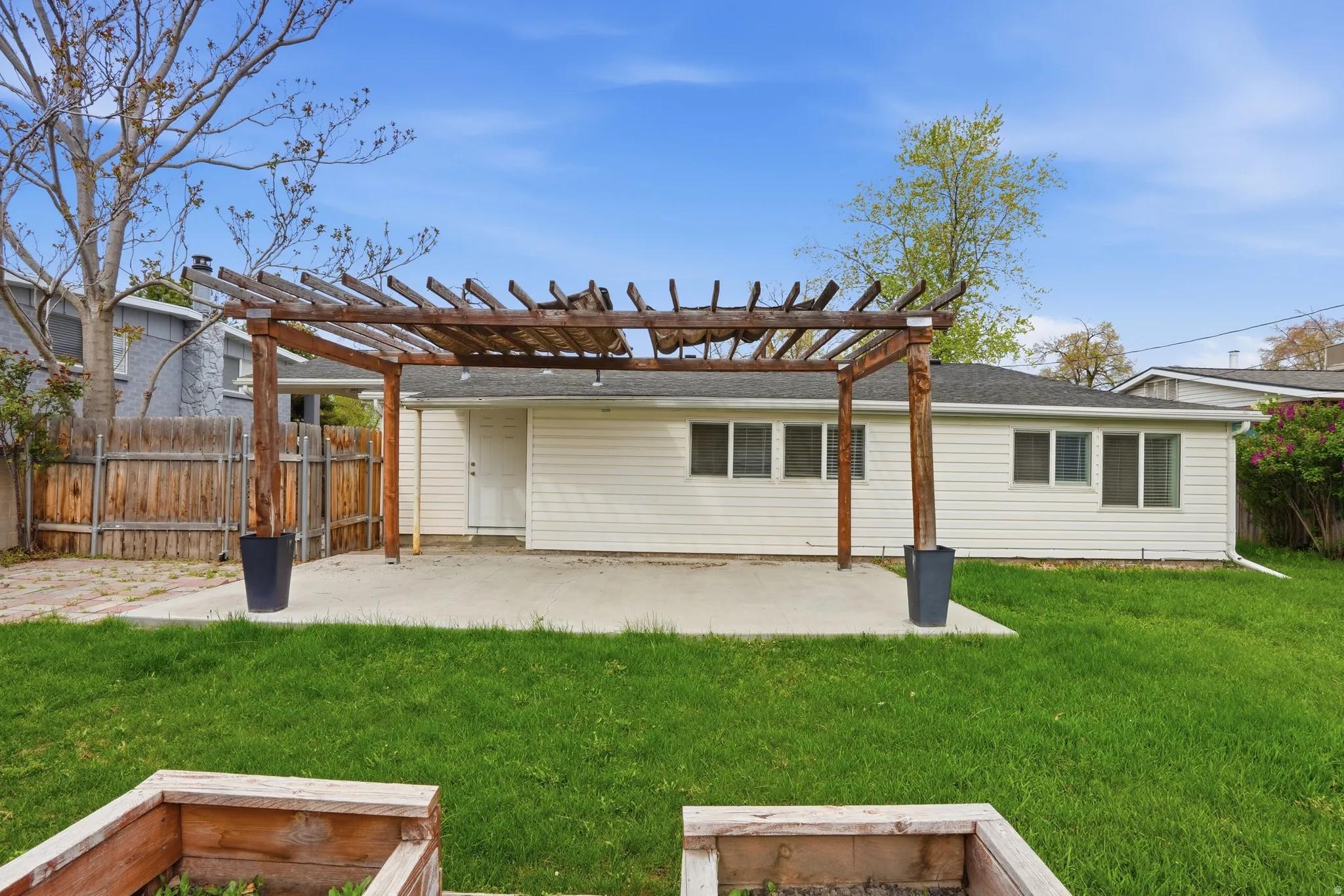 Back of property featuring a patio area, a pergola, and a fenced backyard