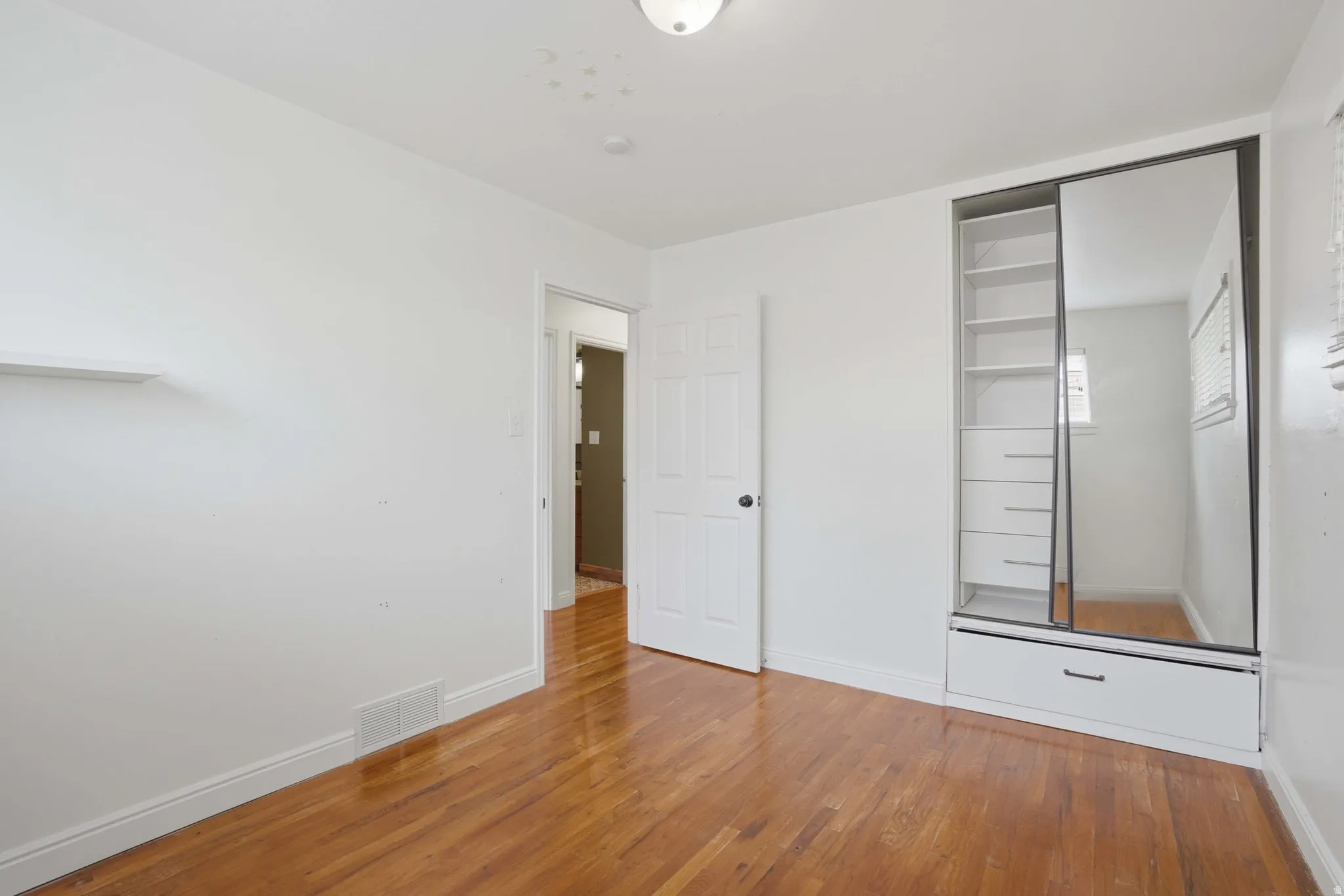 Bedroom 3 with light wood-type flooring and baseboards