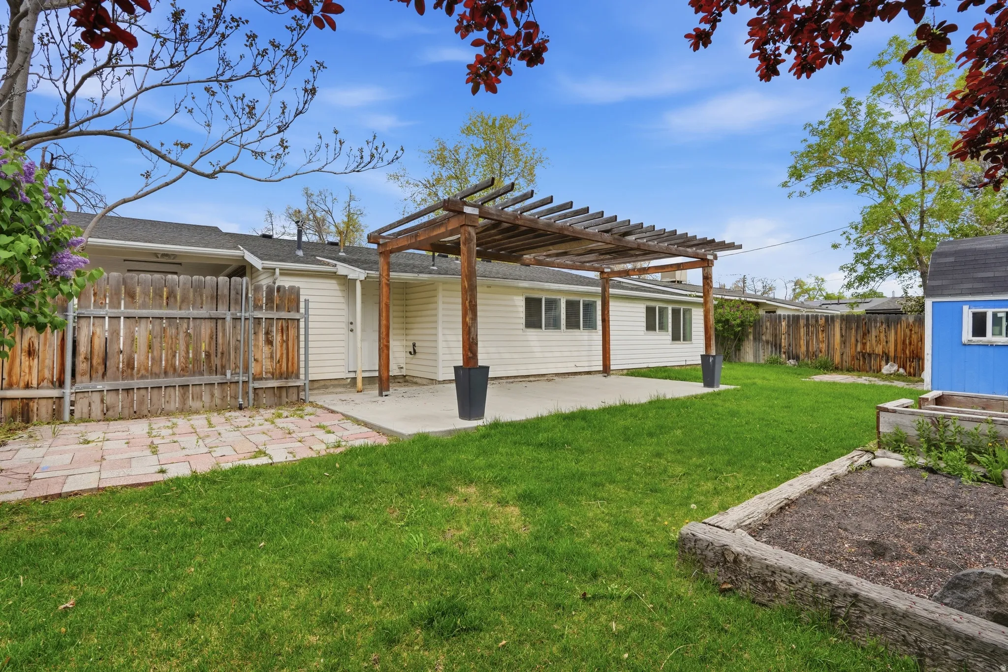 Back of house featuring a patio area, a pergola, a fenced backyard, and an outdoor structure