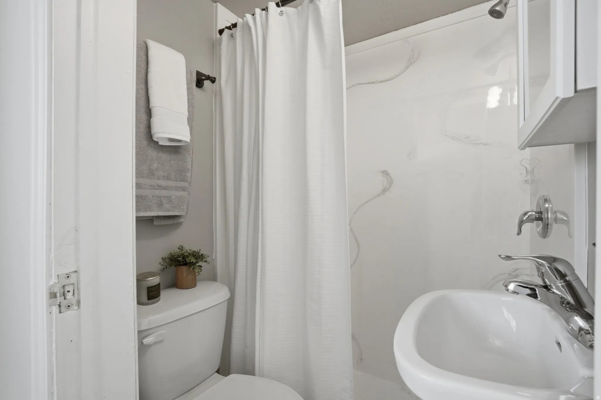 3/4  bath featuring a sink and a shower with shower curtain