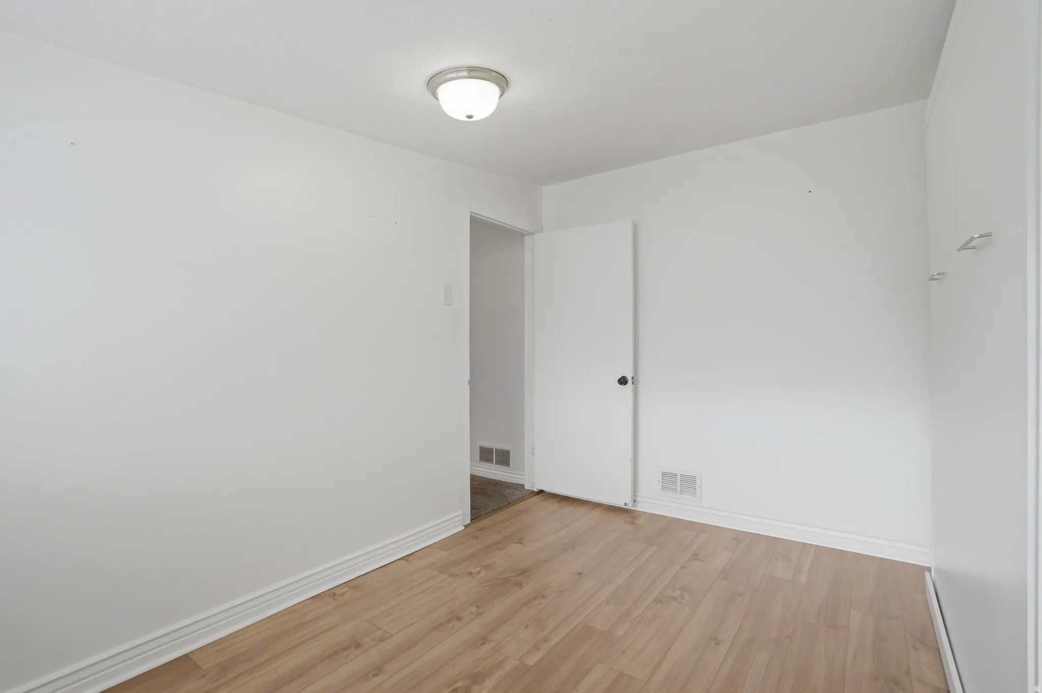 Bedroom 4 featuring light wood finished floors and baseboards