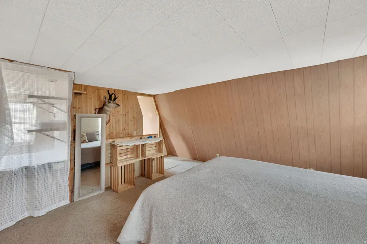 Bedroom featuring carpet floors and wood walls