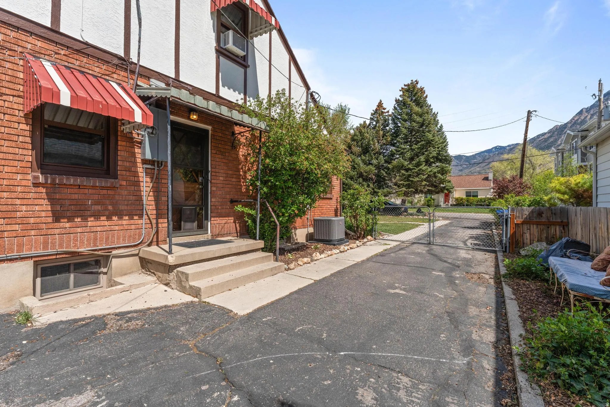 Doorway to property featuring a gate, brick siding, and stucco siding