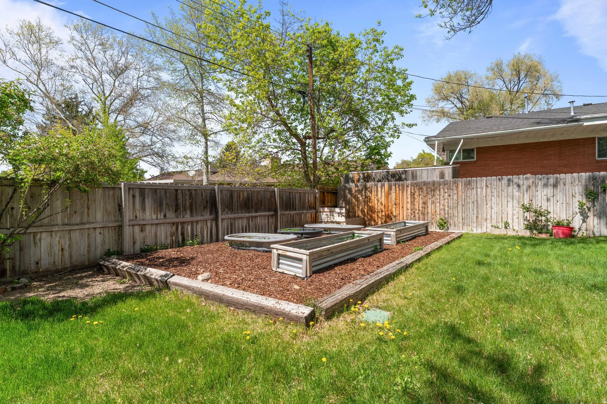 Fenced backyard featuring a garden