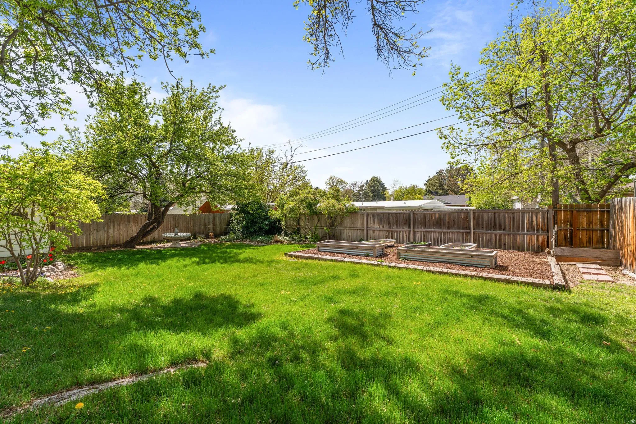 Fenced backyard featuring a vegetable garden
