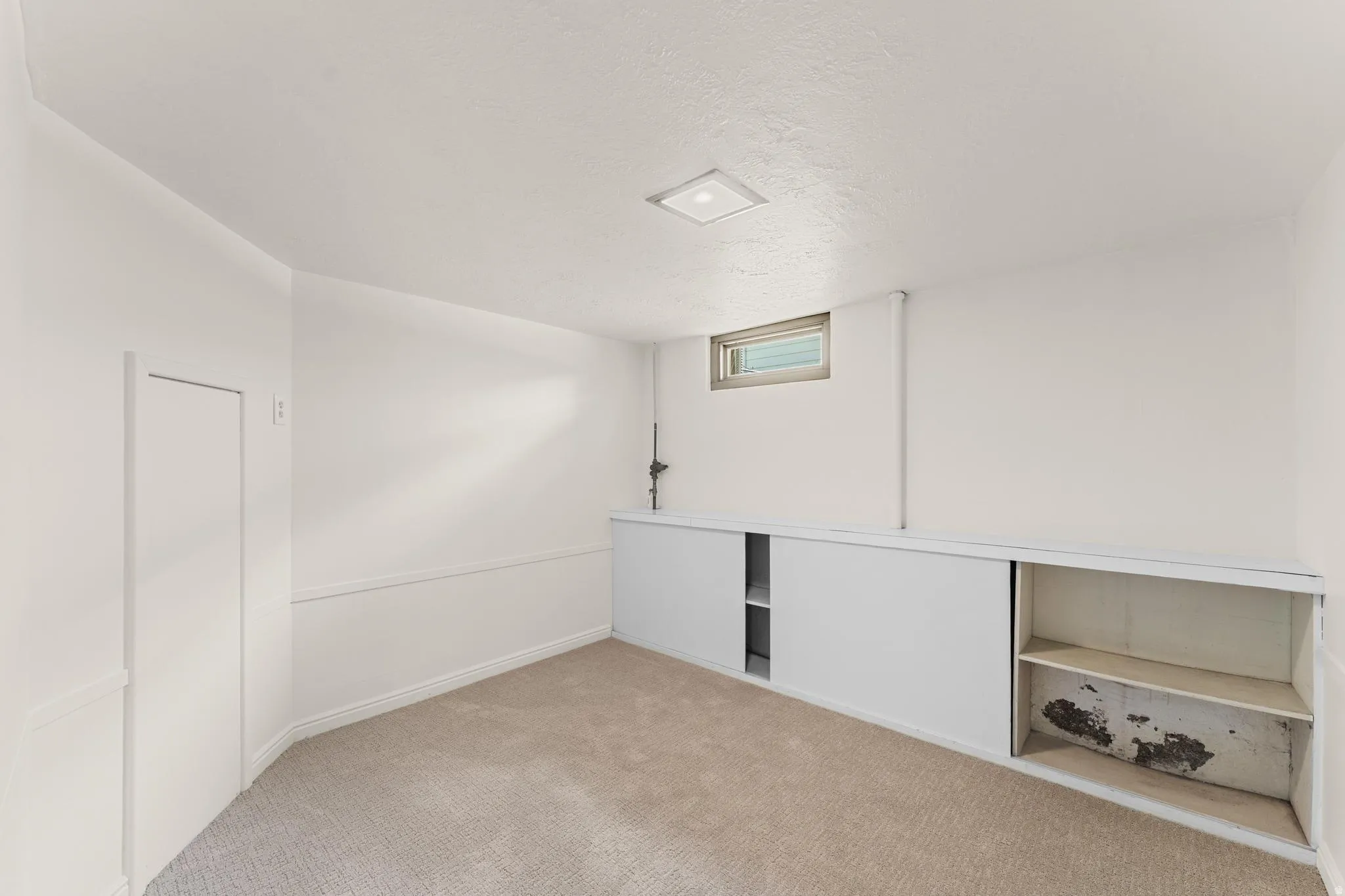 Basement featuring carpet flooring and a textured ceiling