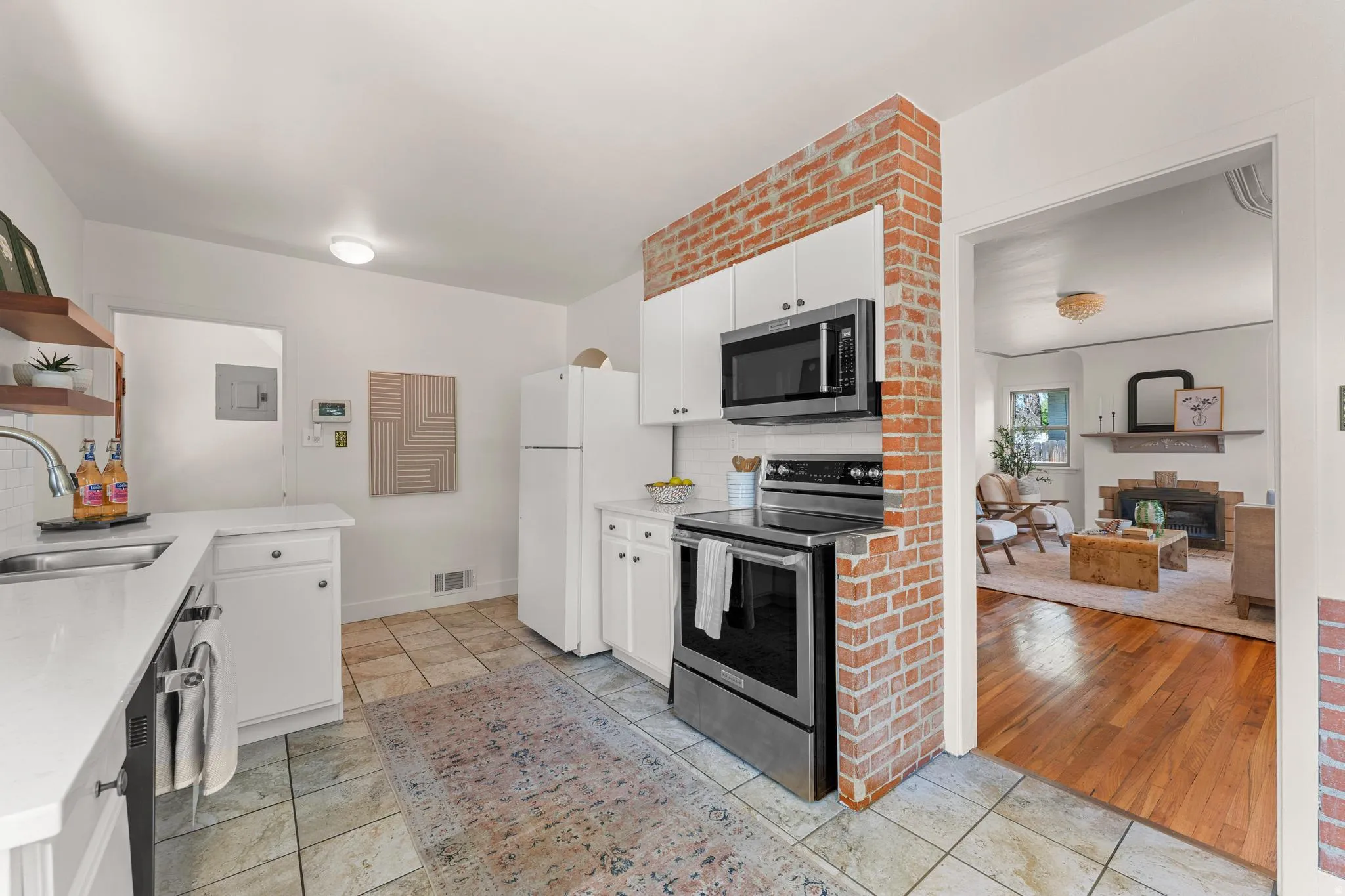 Kitchen with white cabinetry, stainless steel appliances, decorative backsplash, a peninsula, and open shelves