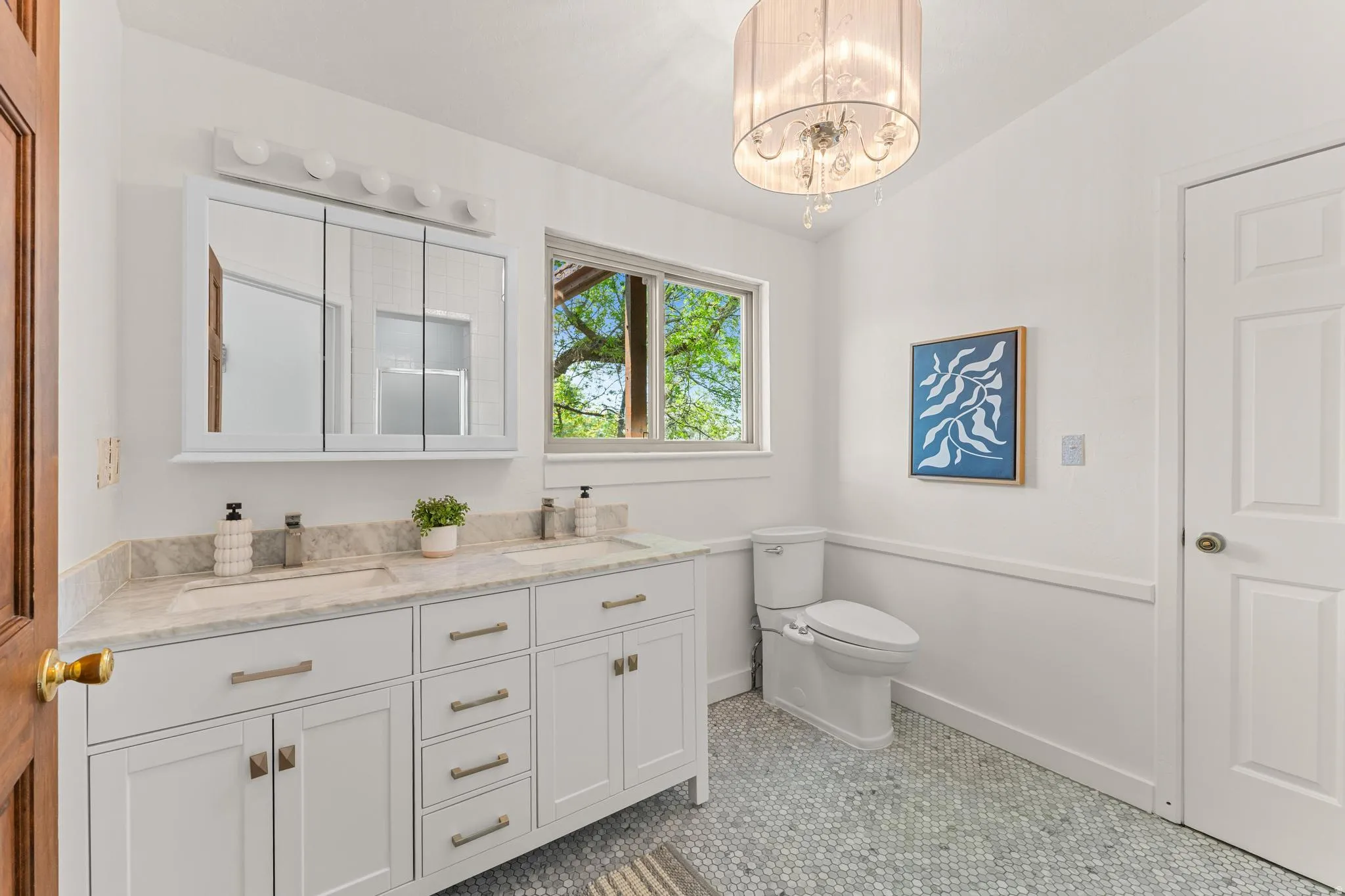 Bathroom featuring double vanity, light tile patterned floors, and hanging lights