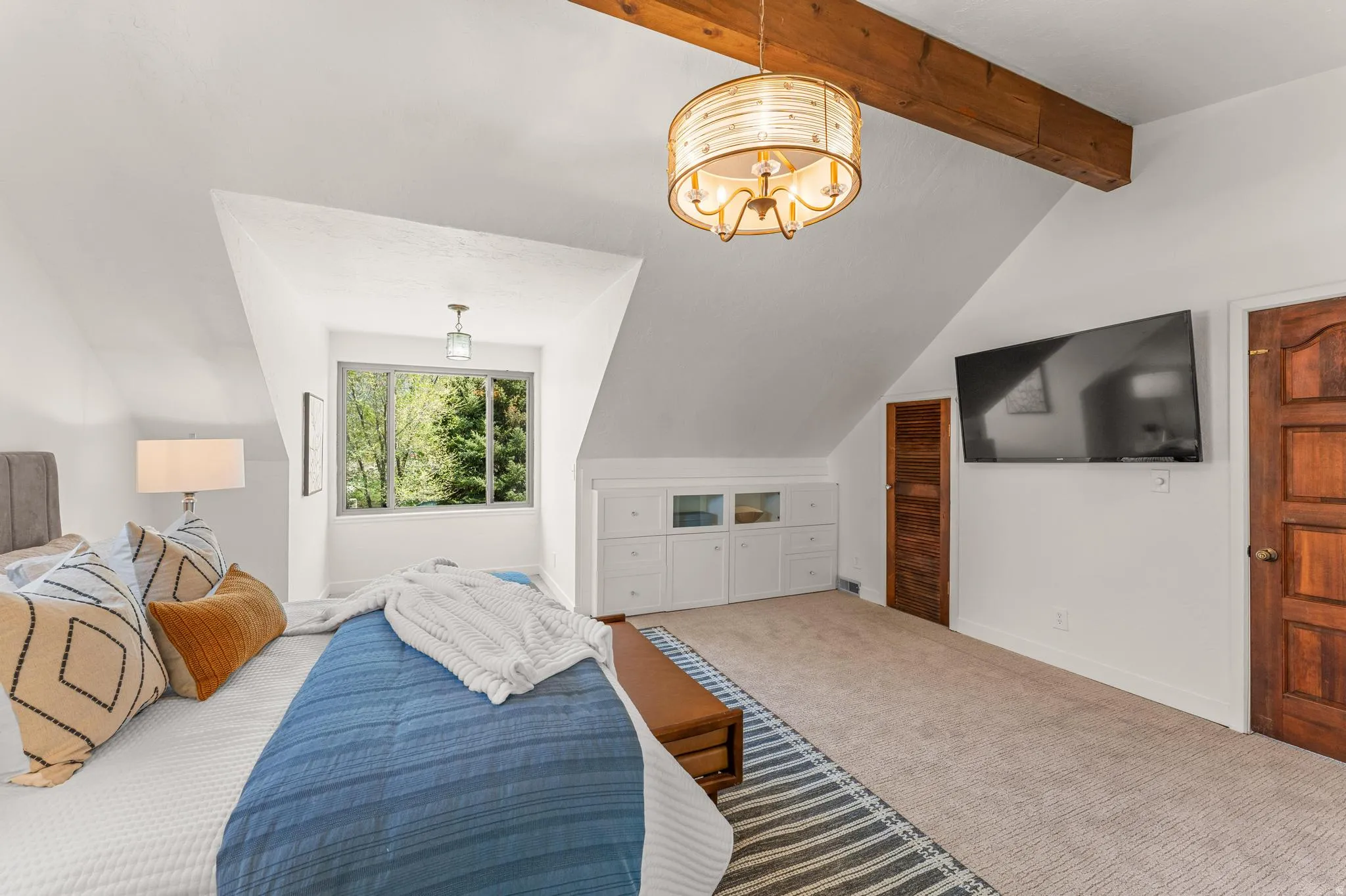 Bedroom with carpet, lofted ceiling with beams, and hanging lights