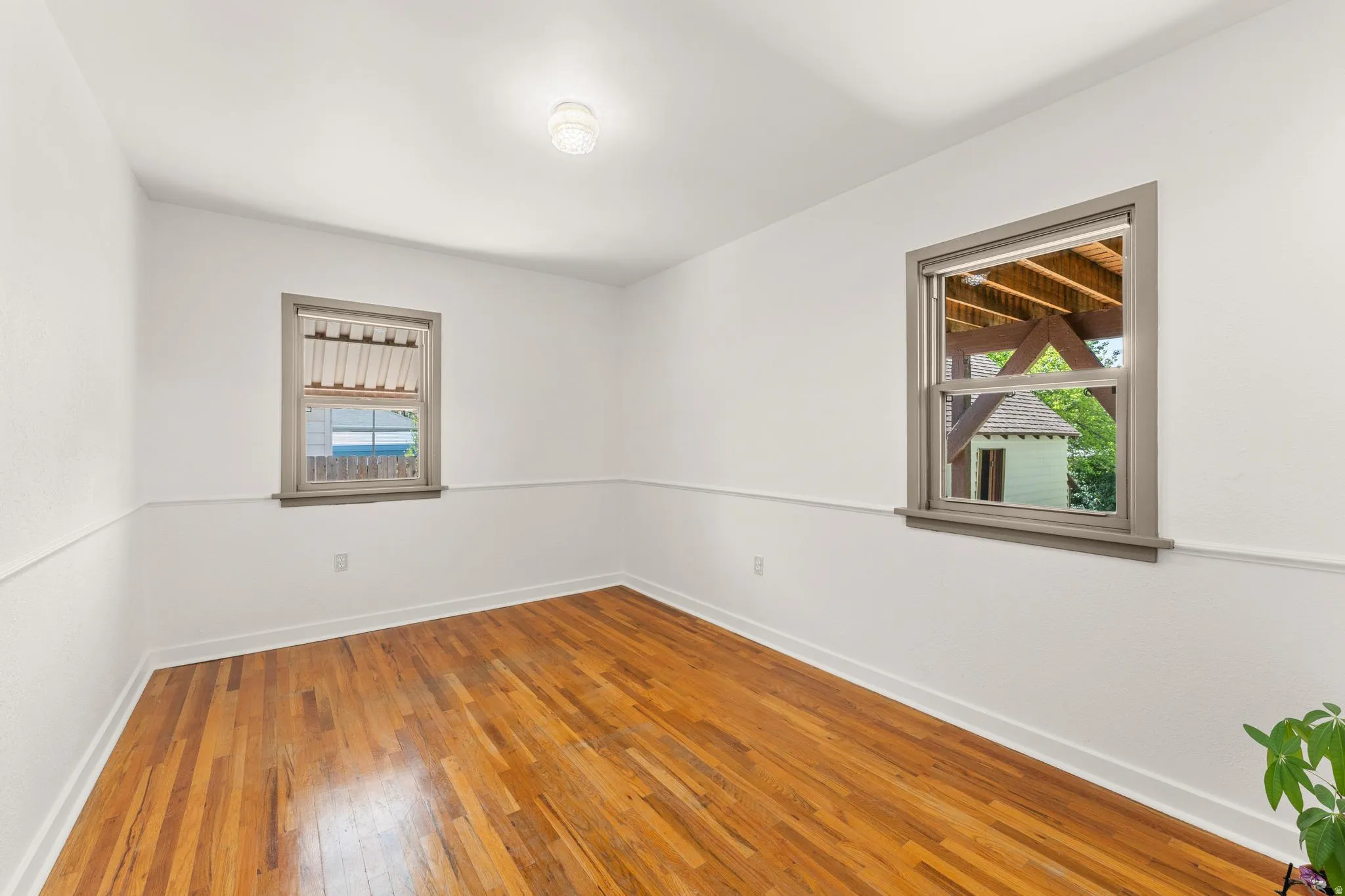 Empty room with hardwood / wood-style floors and baseboards