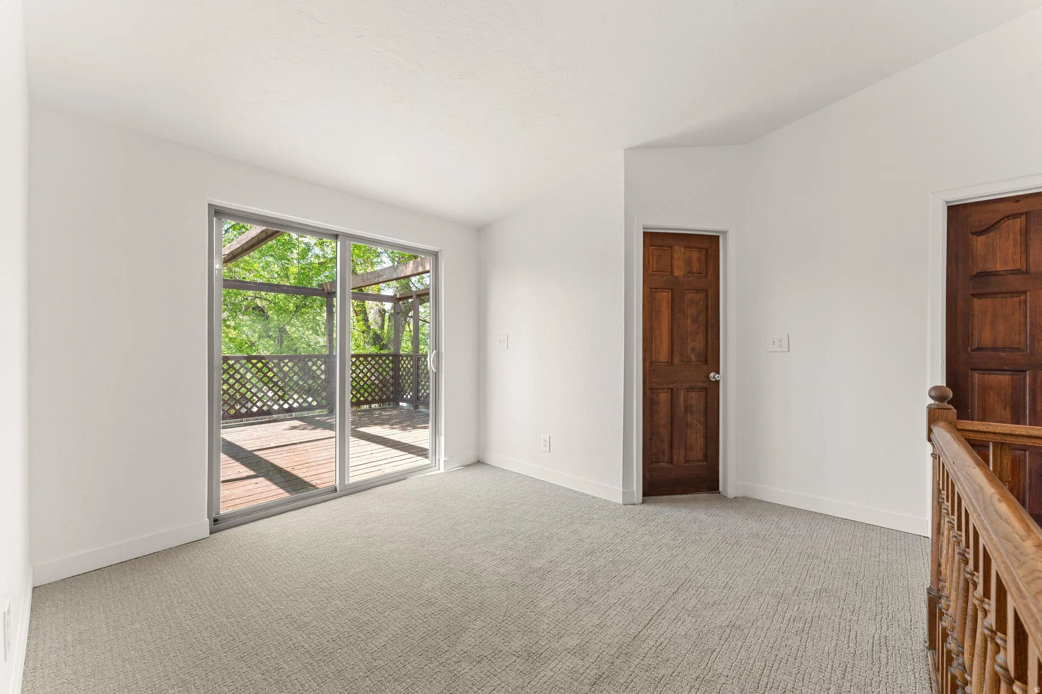 Spare room featuring lofted ceiling and light colored carpet