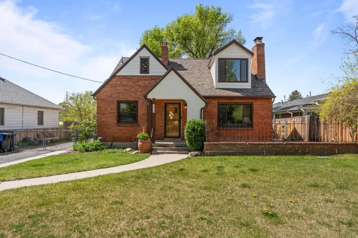 Tudor home with a chimney, brick siding, and roof with shingles