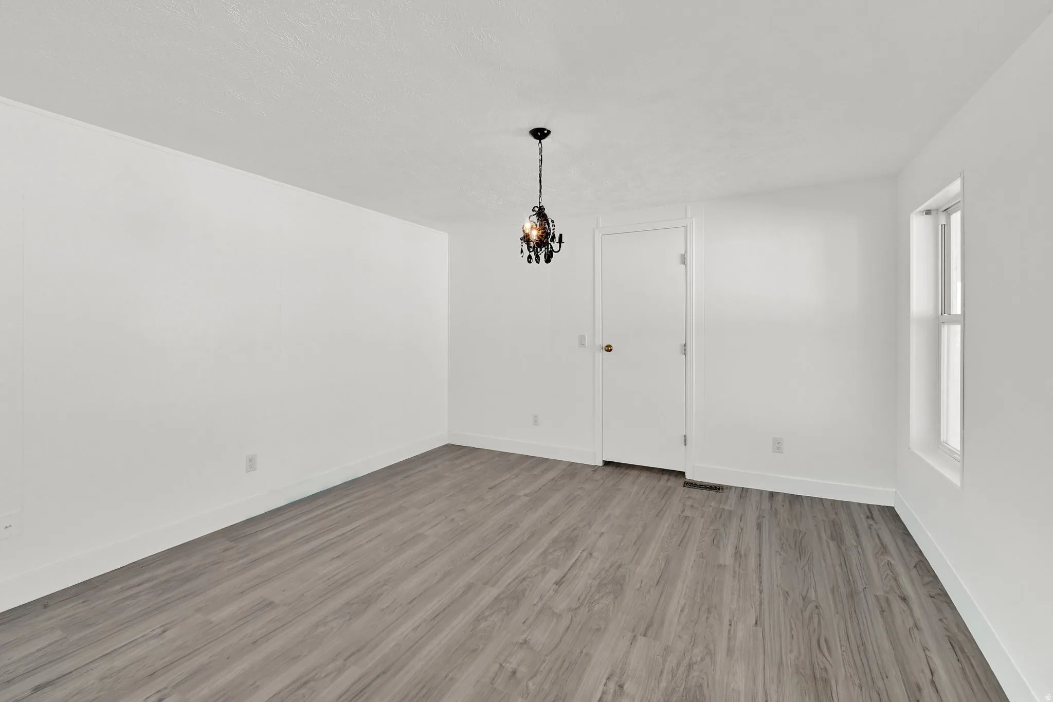 Unfurnished dining area featuring light wood-type flooring and baseboards