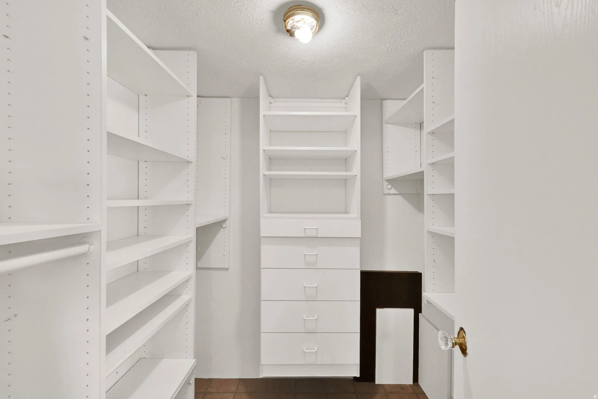 Walk in closet with dark tile patterned flooring