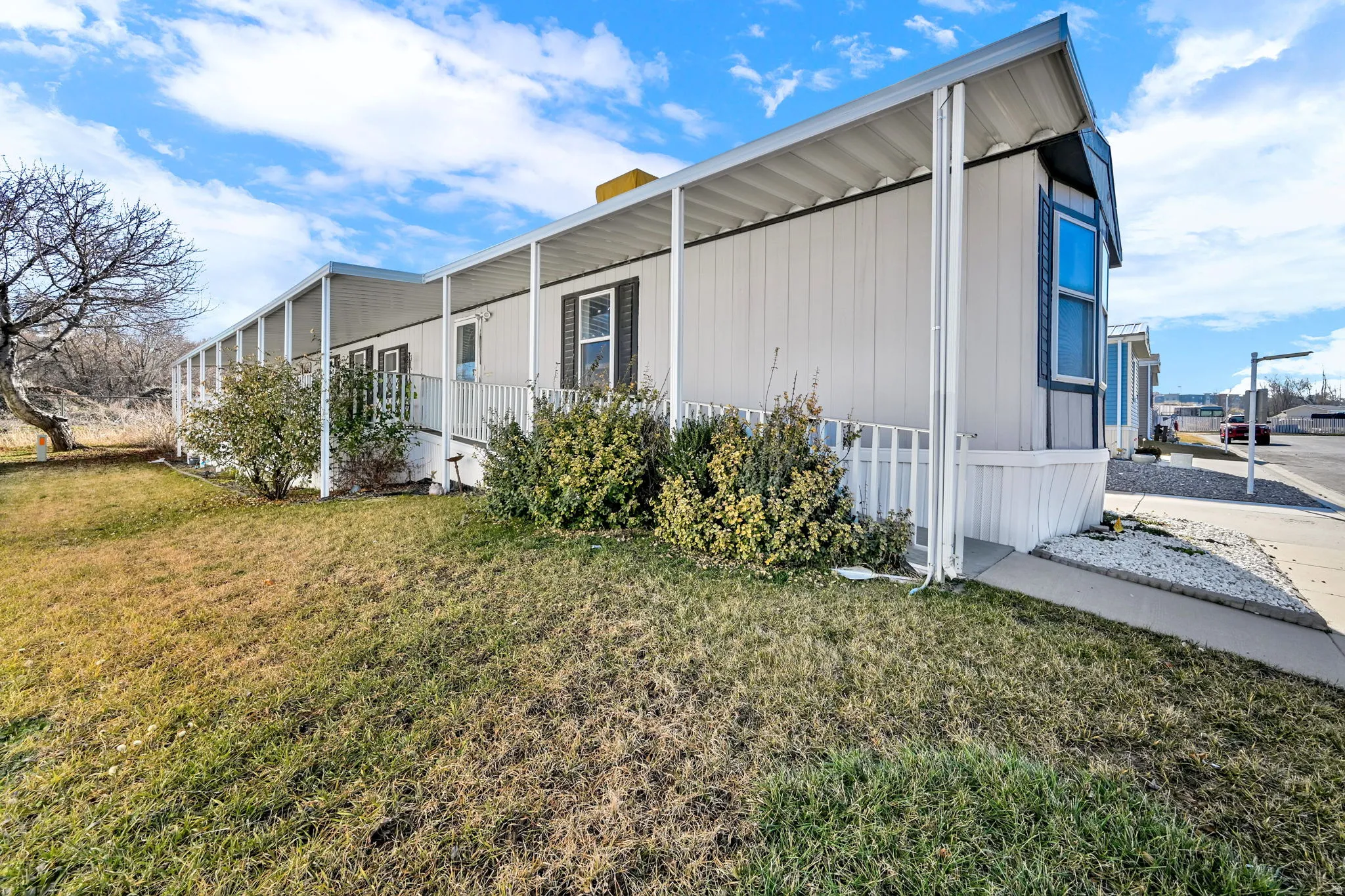 View of side of home with a yard, board and batten siding, and a porch