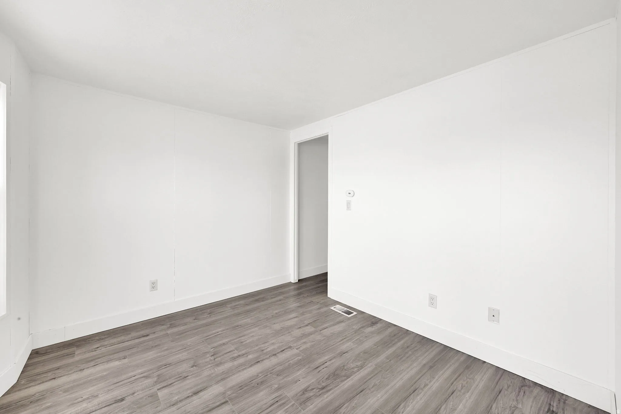 Unfurnished room featuring light wood finished floors and baseboards