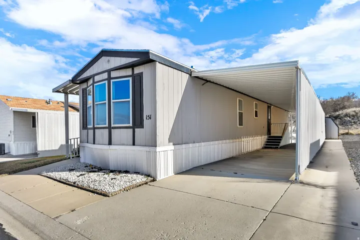 View of front of house with an attached carport, driveway, and entry steps