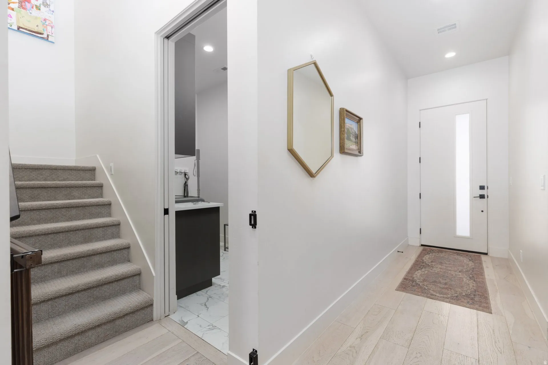 Entrance foyer with light wood-style flooring and recessed lighting
