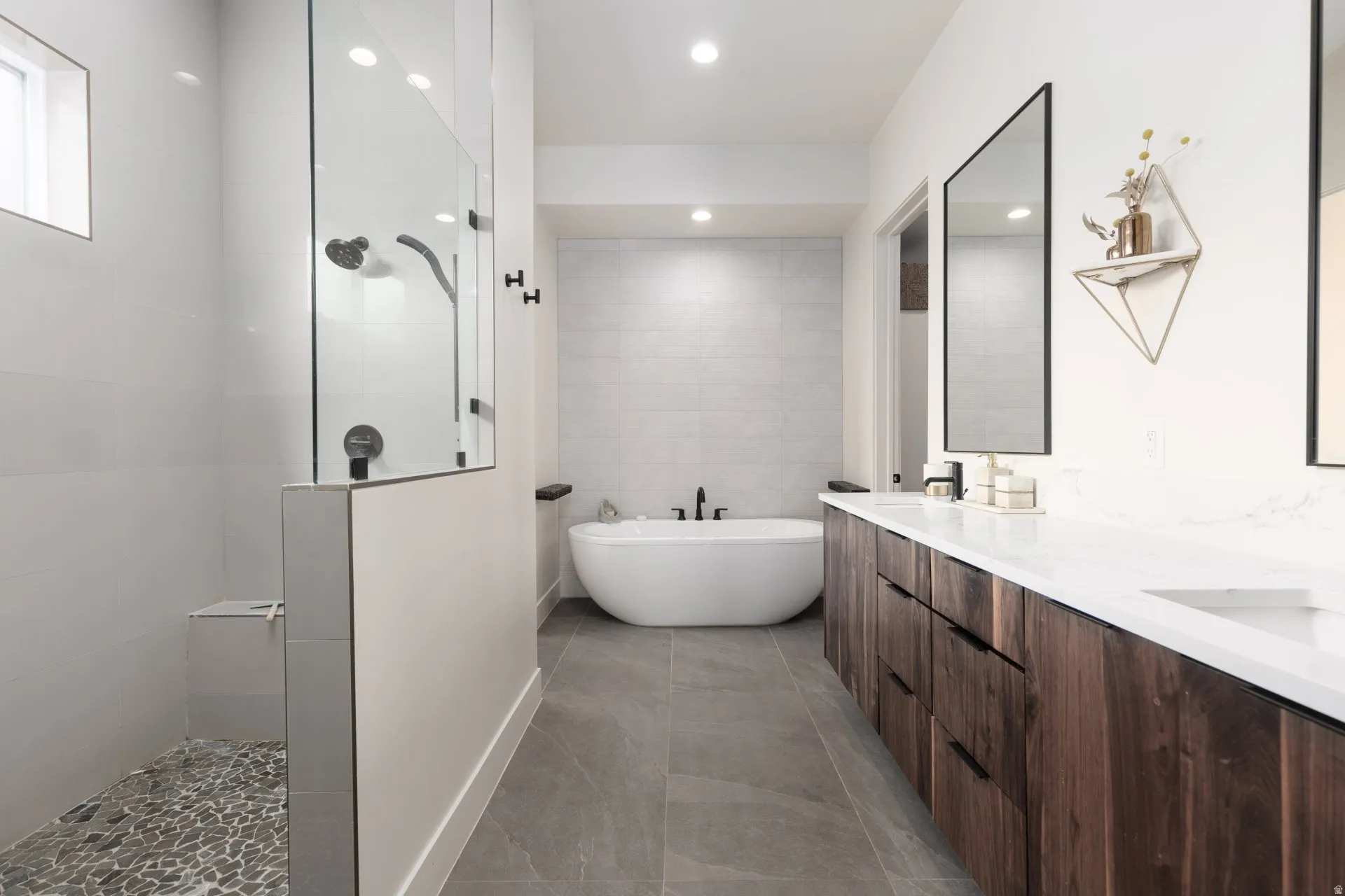 Full bathroom with a walk in shower, double vanity, a freestanding bath, recessed lighting, and tile walls