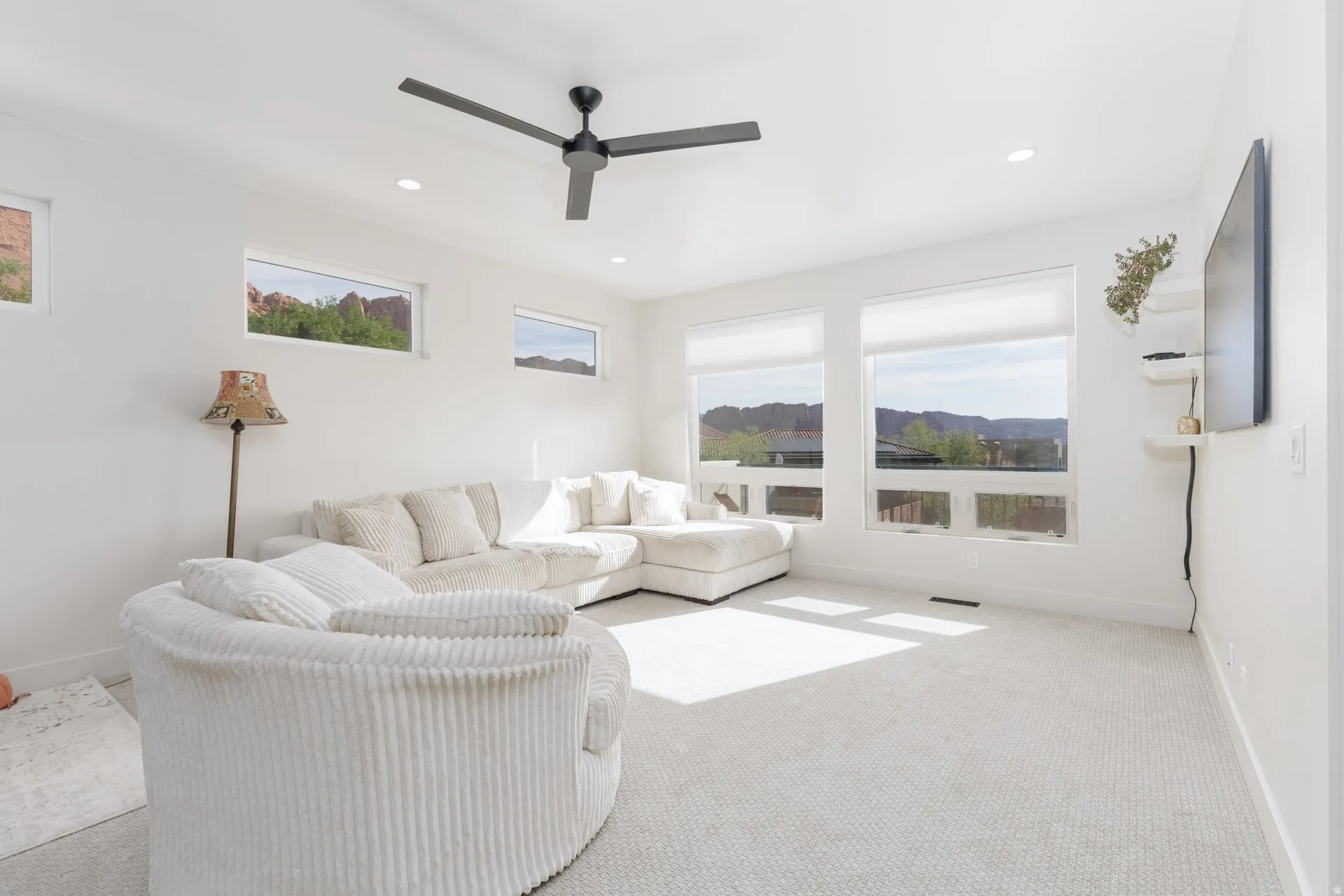 Living area featuring carpet, healthy amount of natural light, a ceiling fan, and recessed lighting