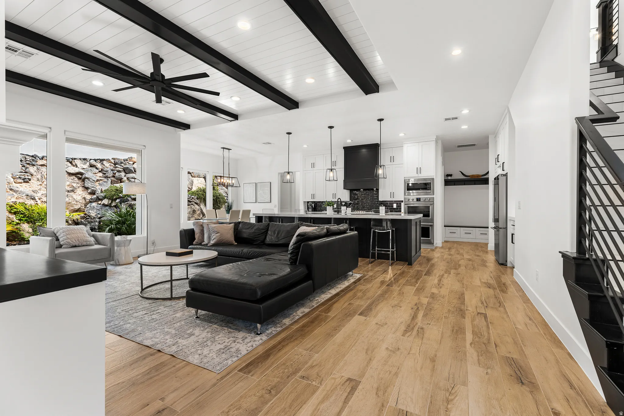 Living room with recessed lighting, light wood finished floors, ceiling fan, and beamed ceiling