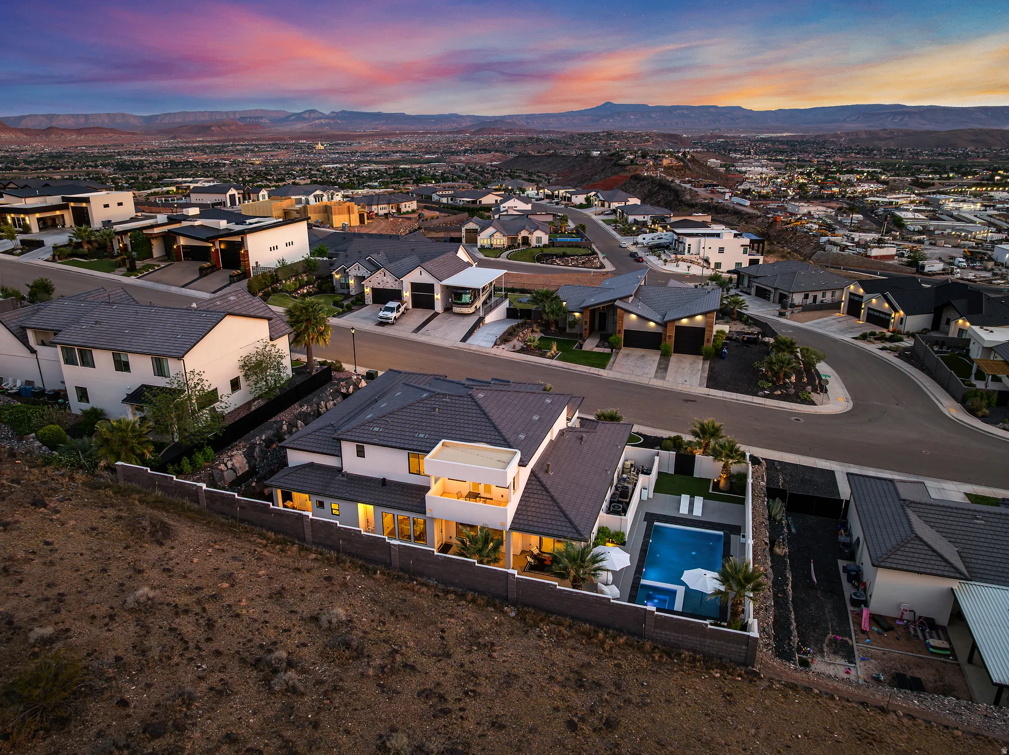 Aerial view of residential area with a pool area and a mountainous background