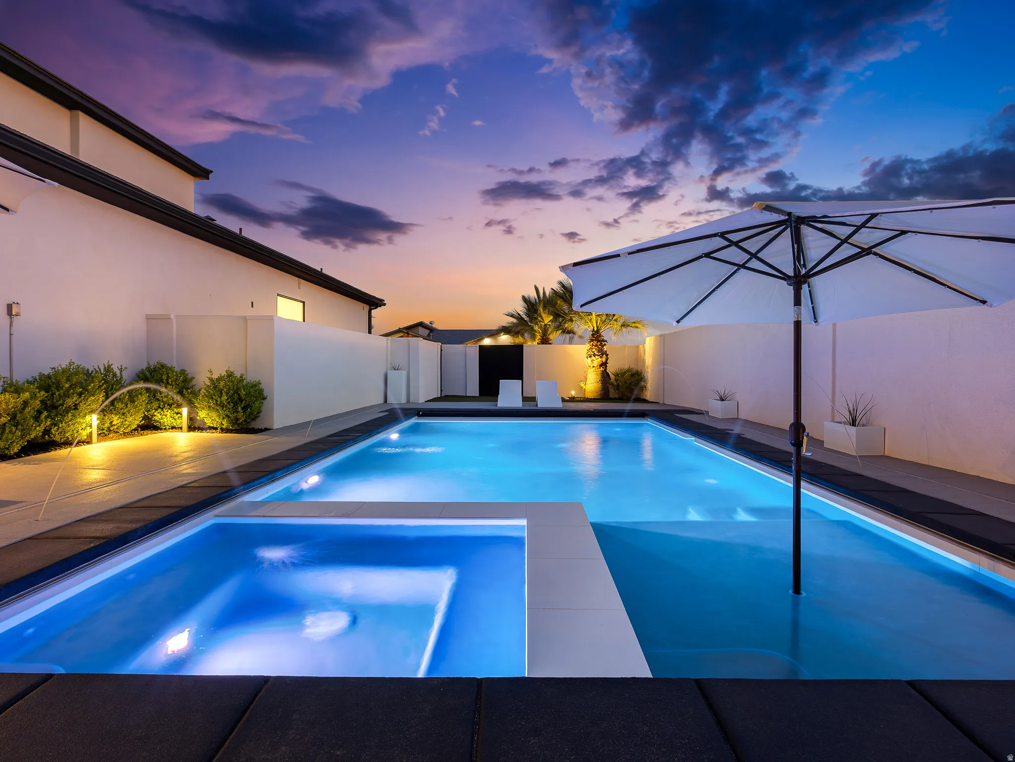 Integrated pool / hot tub featuring a fenced backyard