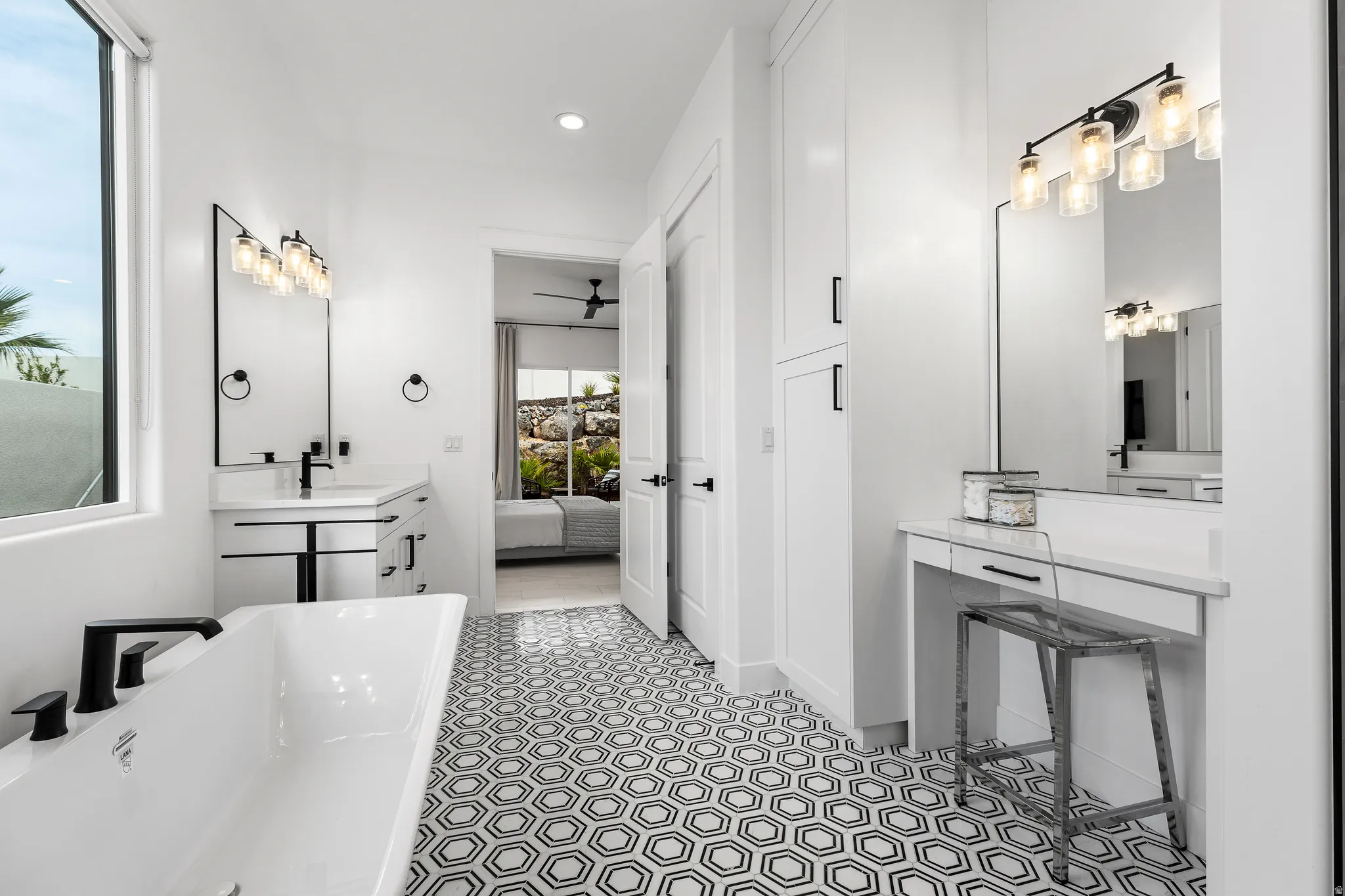 Ensuite bathroom featuring vanity, a freestanding bath, recessed lighting, and a ceiling fan
