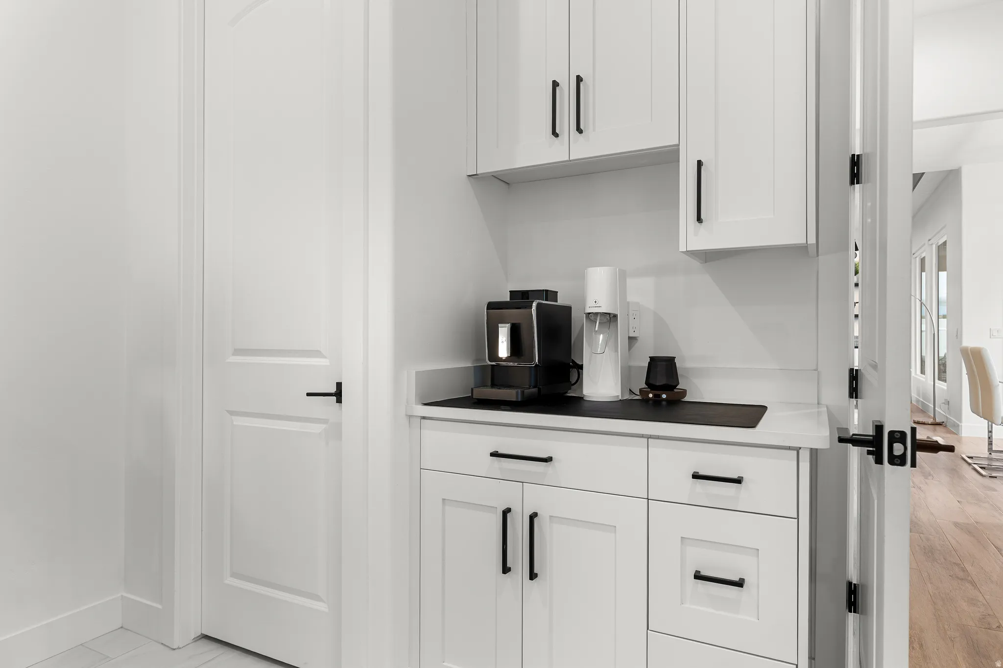 Bar area with white cabinets and light countertops