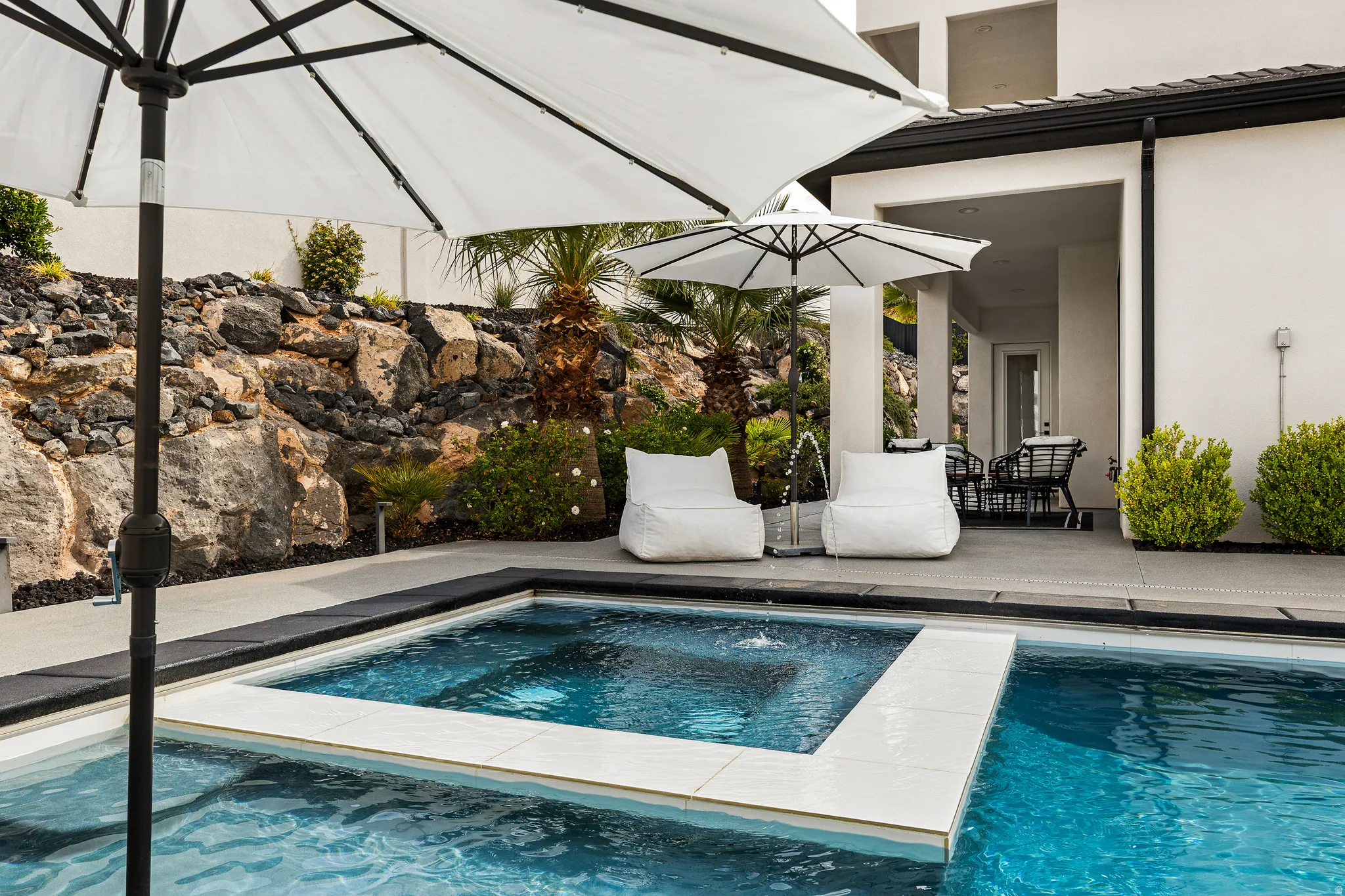 Outdoor pool with a patio area, outdoor dining space, and an in-ground hot tub