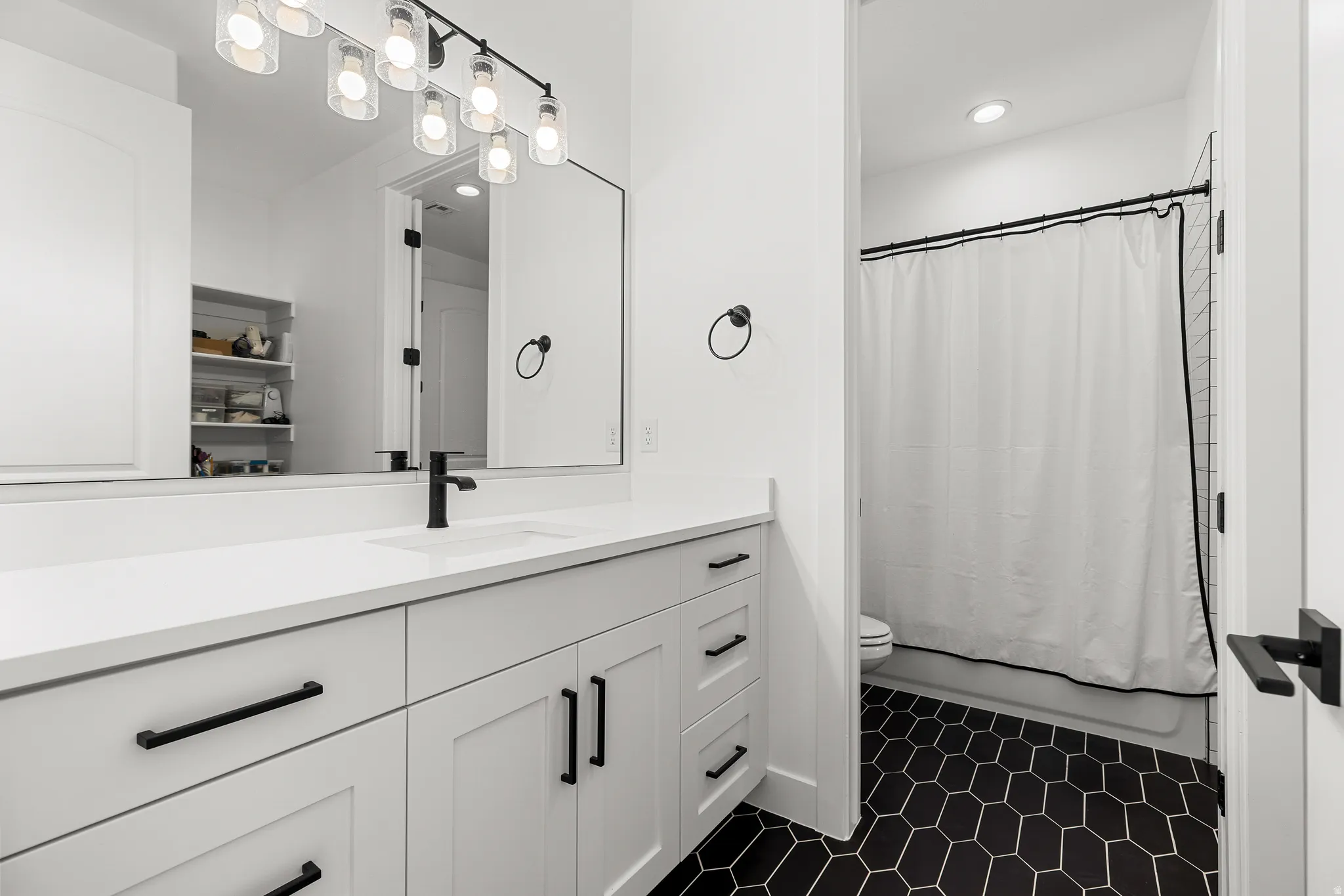 Bathroom with vanity, shower / tub combo, and recessed lighting