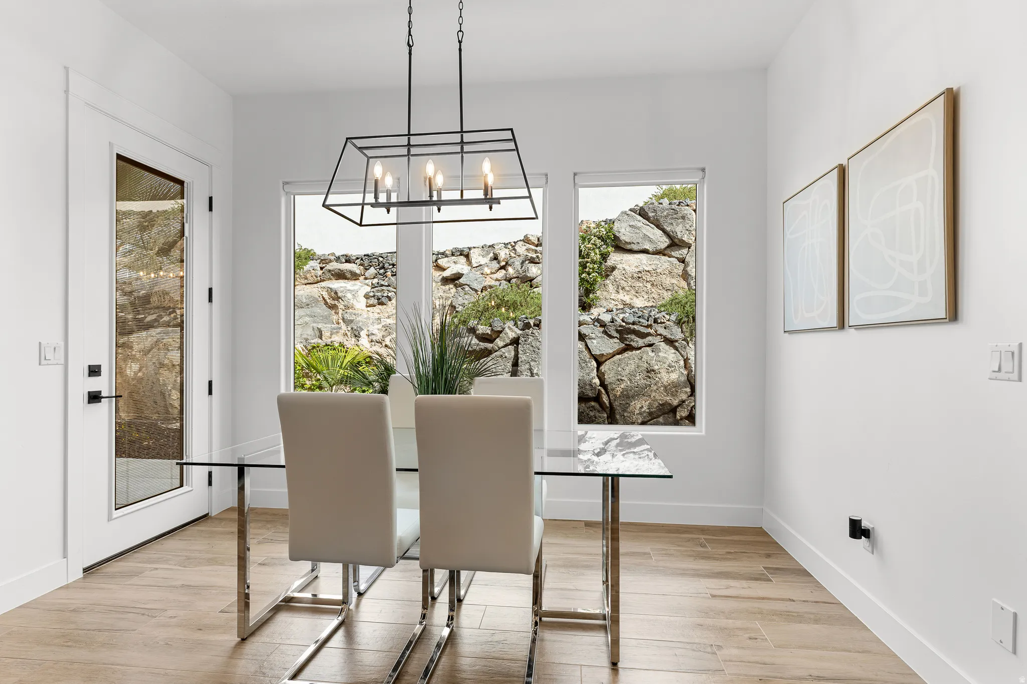 Dining space with hanging lights and light wood-style flooring