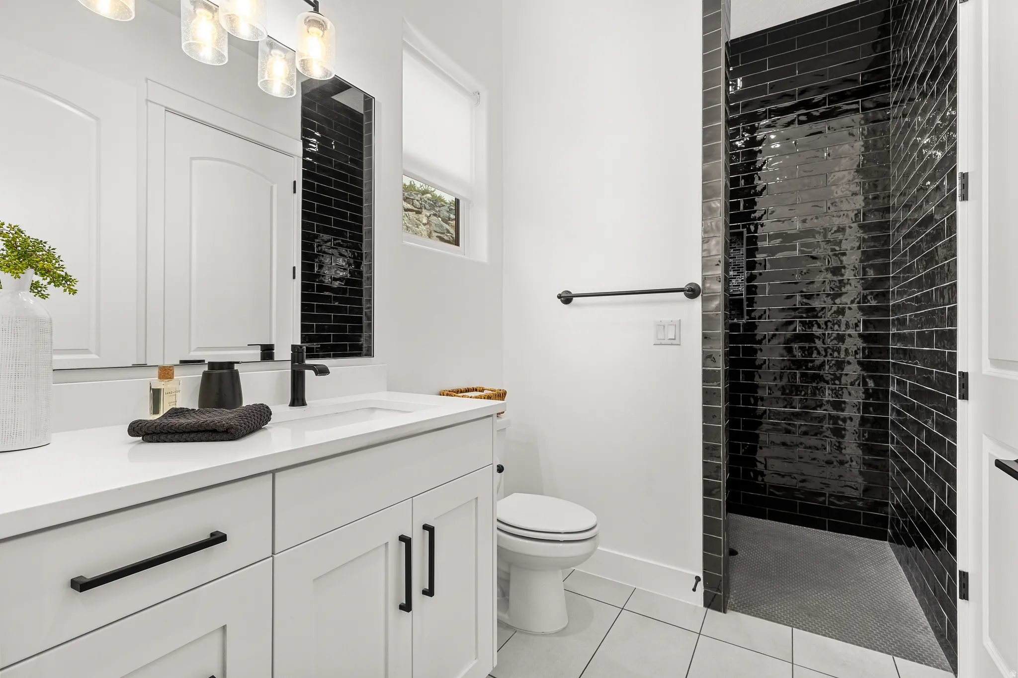 Bathroom with vanity, light tile patterned flooring, and tiled shower