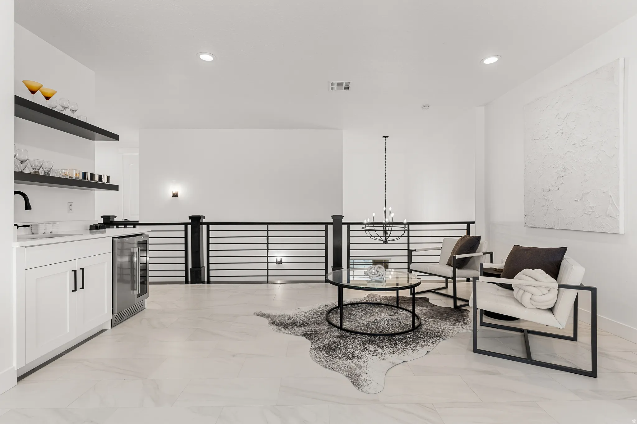Sitting room with beverage cooler, a chandelier, and light marble finish floors
