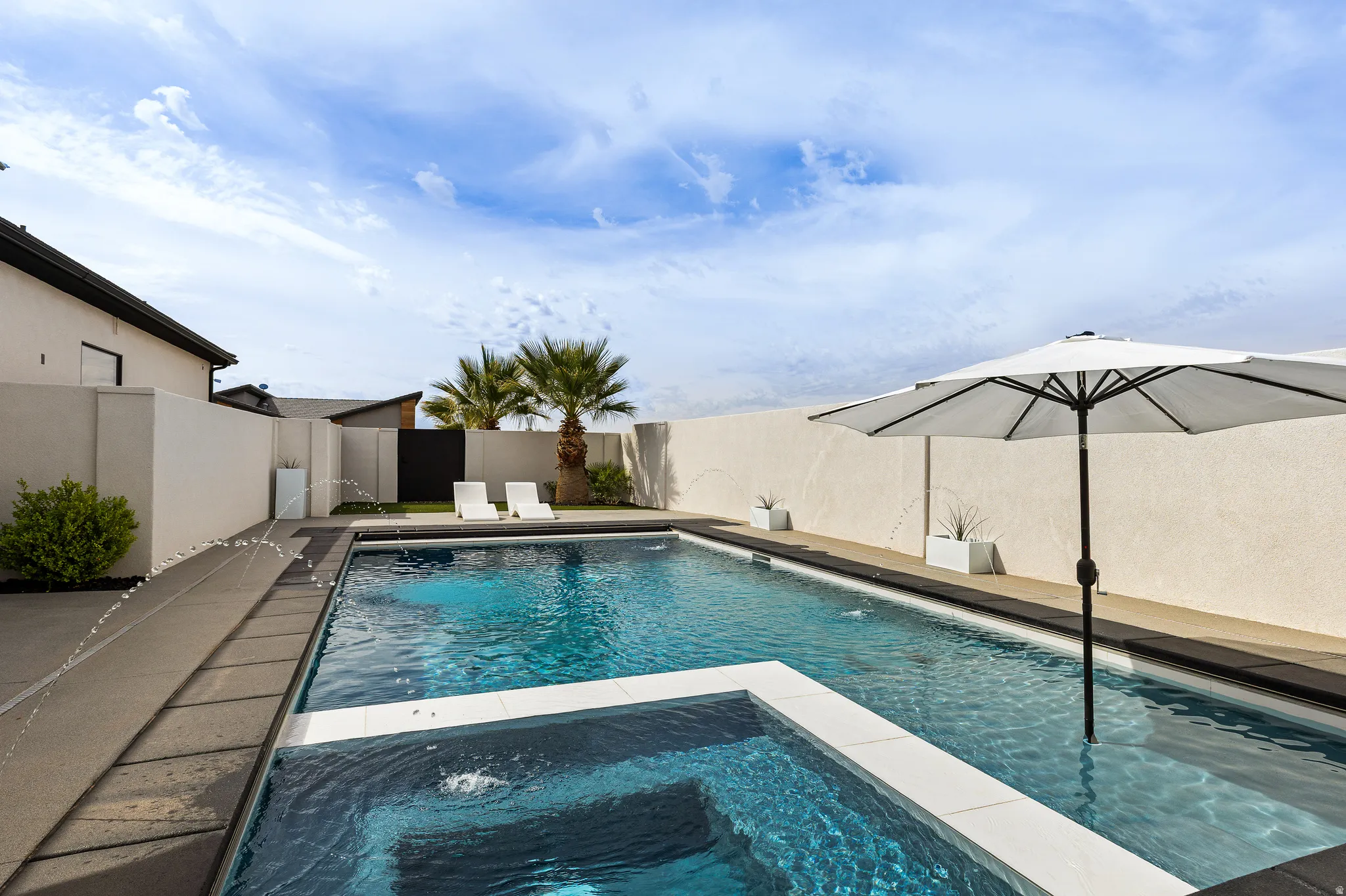 Integrated pool / spa featuring a fenced backyard and a patio area